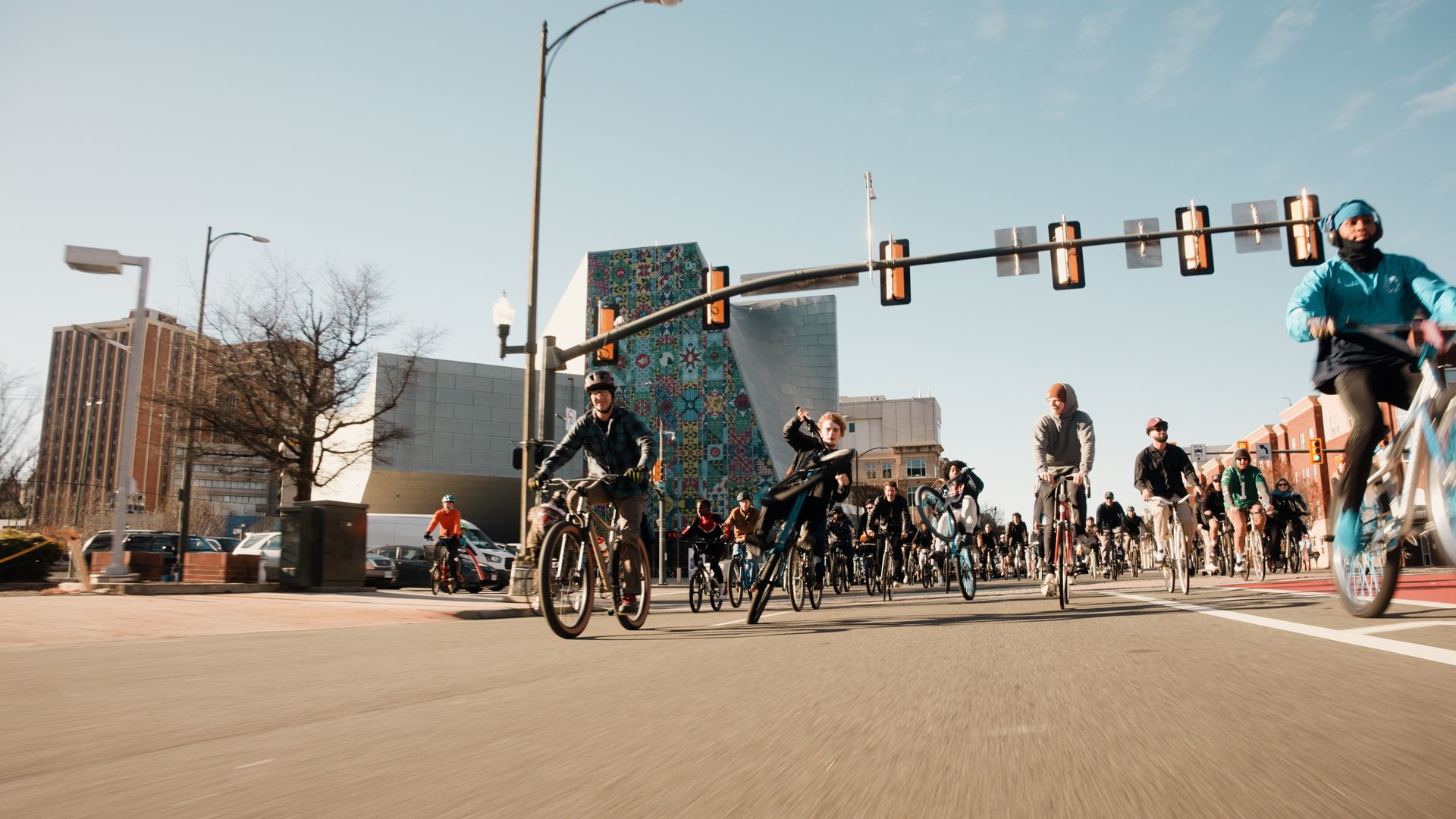A picture of dozens of people on bikes riding on the street with the ICA building behind them.