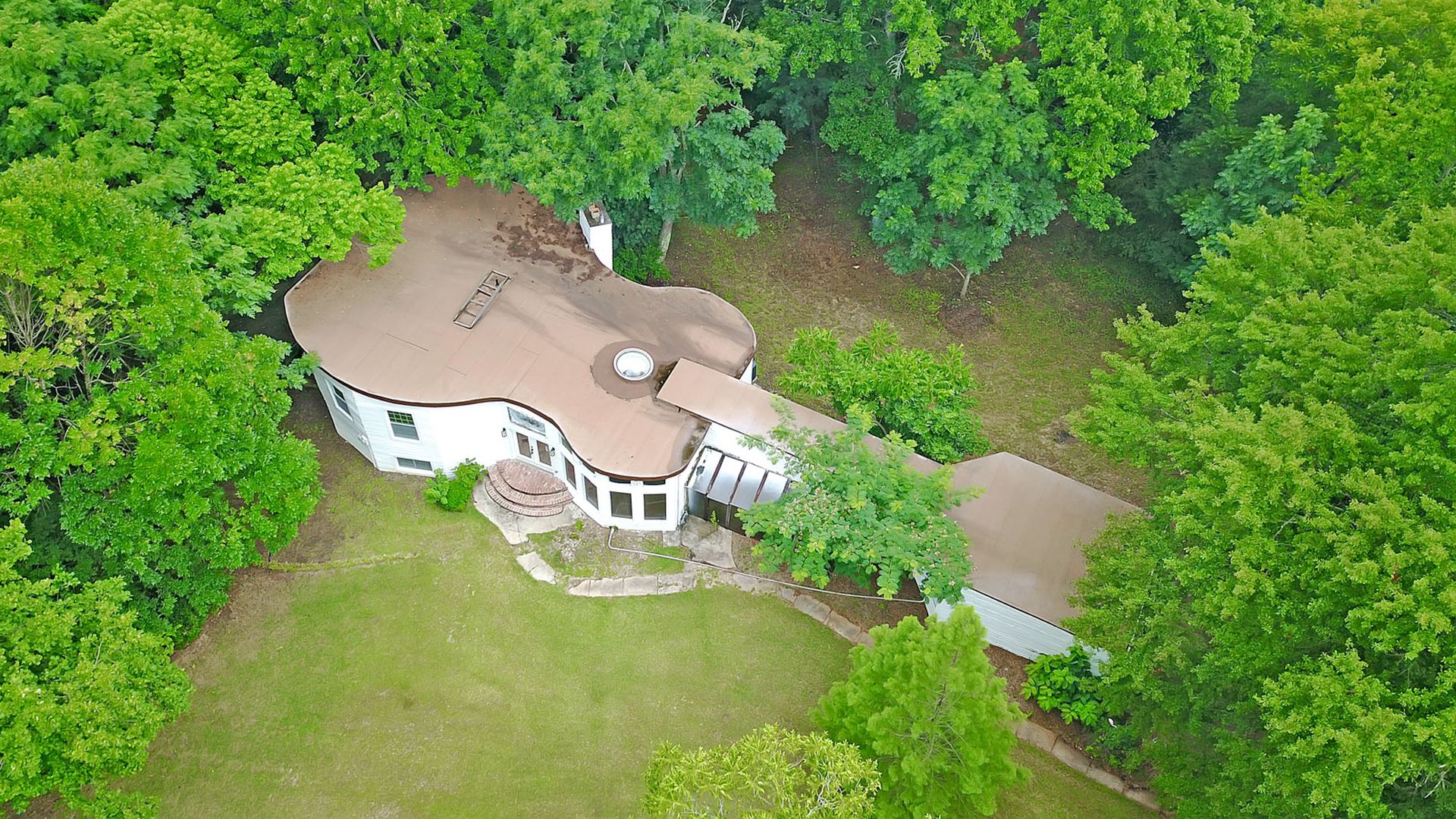 An aerial photo of a house that's shaped like a guitar
