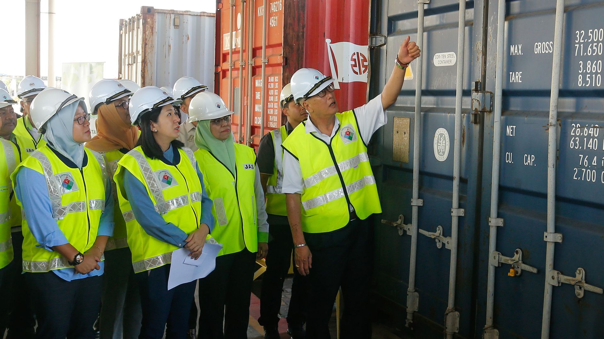 Malaysian Environment Minister Yeo Bee Yin (front 2nd L) and officials inspect a container containing plastic waste shipment on January 20, 2020 before sending back