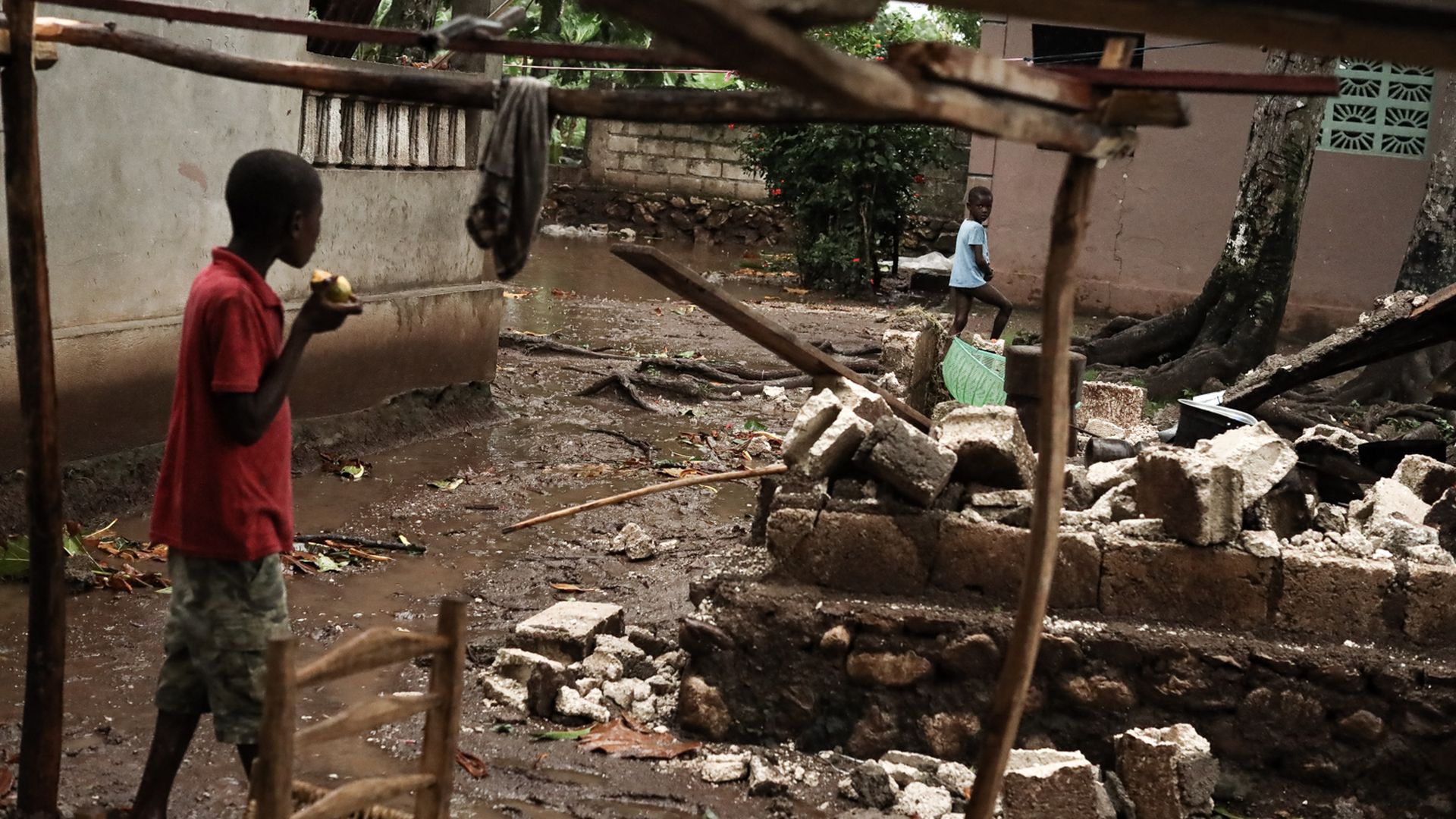 Children walk through flooded streets following a tropical storm in Saint-Louis-du-Sud, Haiti, on  Aug. 17.