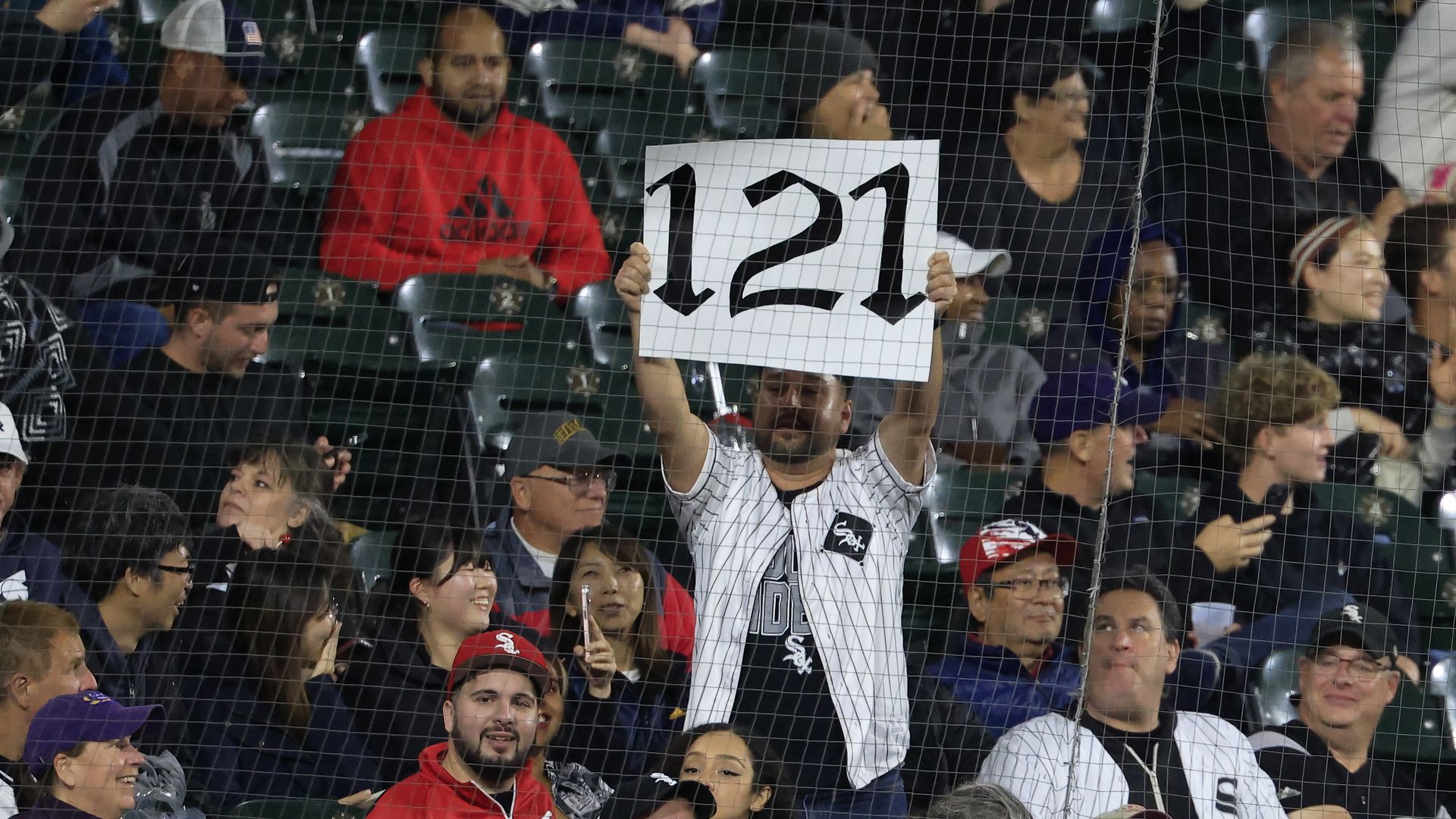 Photo of a fan holding a sign that says 121