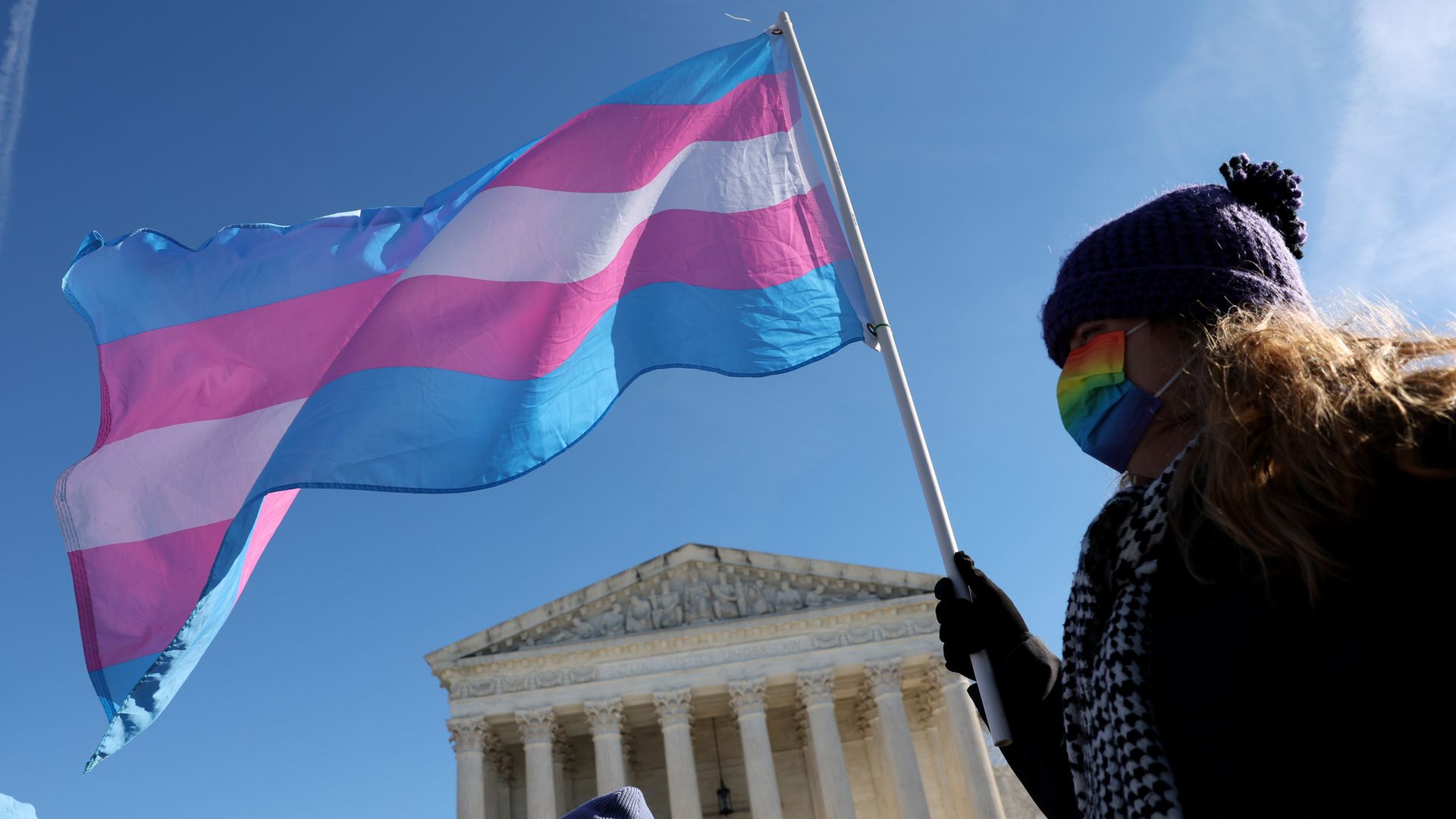 Woman protester waving transgender flag in front of the Supreme Court