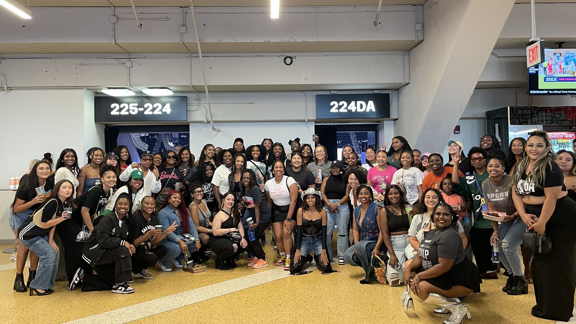 A large group of women gathered in a stadium concourse.
