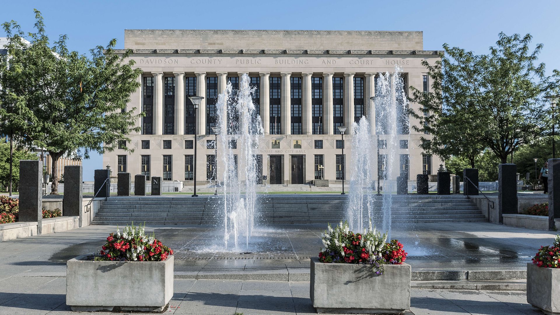 Nashville's city hall on a clear day with fountains surging outside.