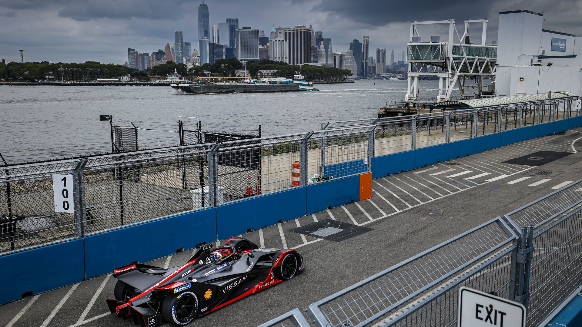 Image of an electric Formula E race car with the NYC skyline in the distance. 