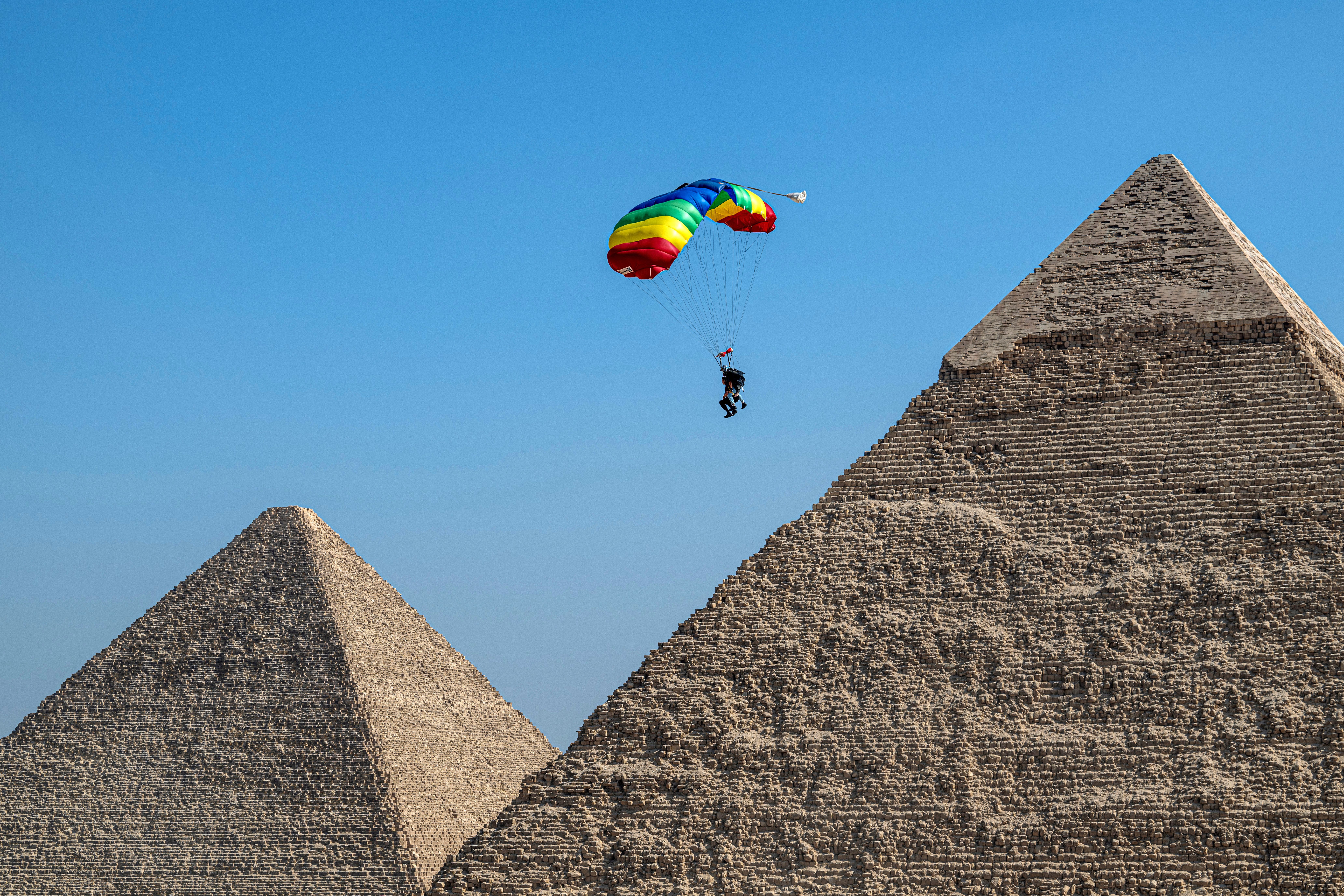 TOPSHOT - A parachutist descends over the pyramid complex during the 7th edition of the Egypt International Skydiving Festival "Jump Like a Pharaoh", at the Giza plateau near Cairo on October 29, 2024. (Photo by Khaled DESOUKI / AFP) (Photo by KHALED DESOUKI/AFP via Getty Images)