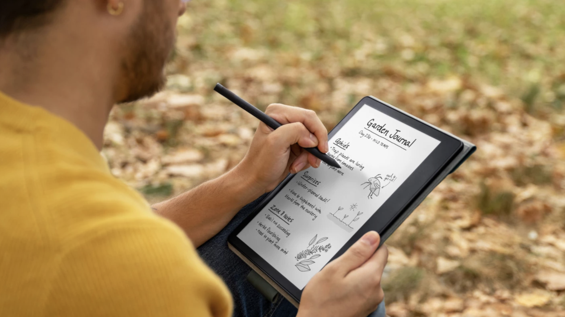 A man writes notes on a Kindle Scribe