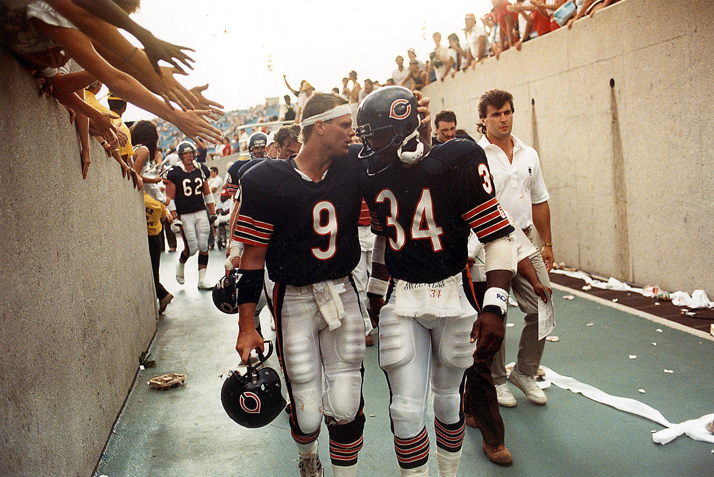Photo of two football players walking off field 