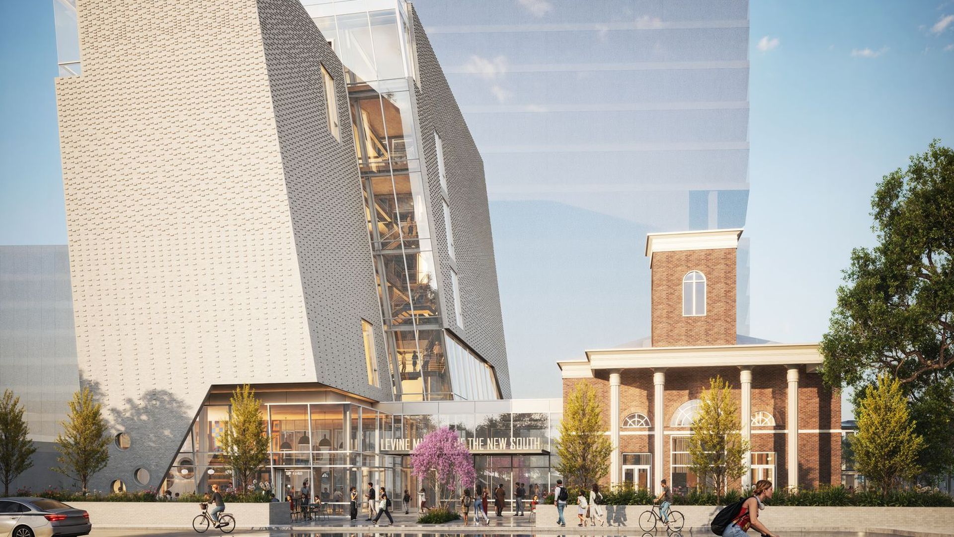 Angular beige tower with a glass atrium sits beside a brick, columned building in a busy plaza. People walk, cyclists pass, and trees line the sunny square.