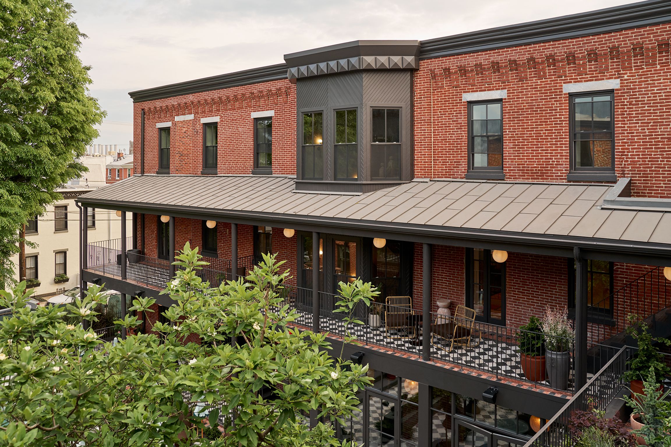 A balcony area outside of the boutique hotel's rooms, with tiled flooring and reclining chairs.