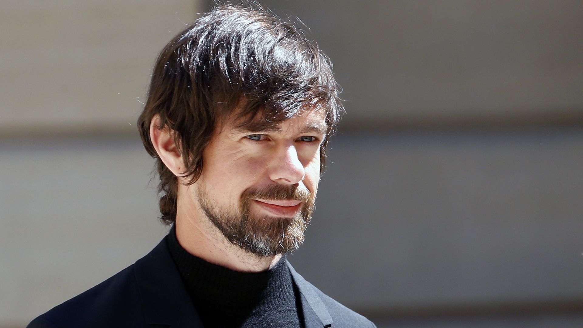 Photo of smiling Twitter CEO Jack Dorsey in black shirt and jacket