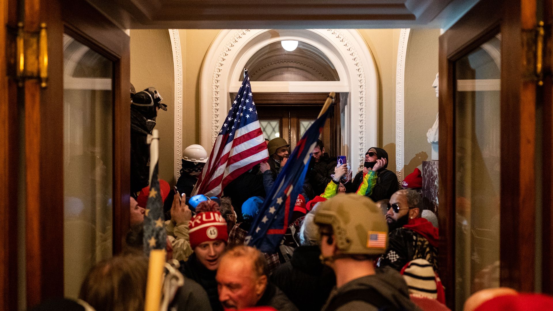 Photo of a mob of Trump supporters crowded into a Capitol hallway with signs and banners 