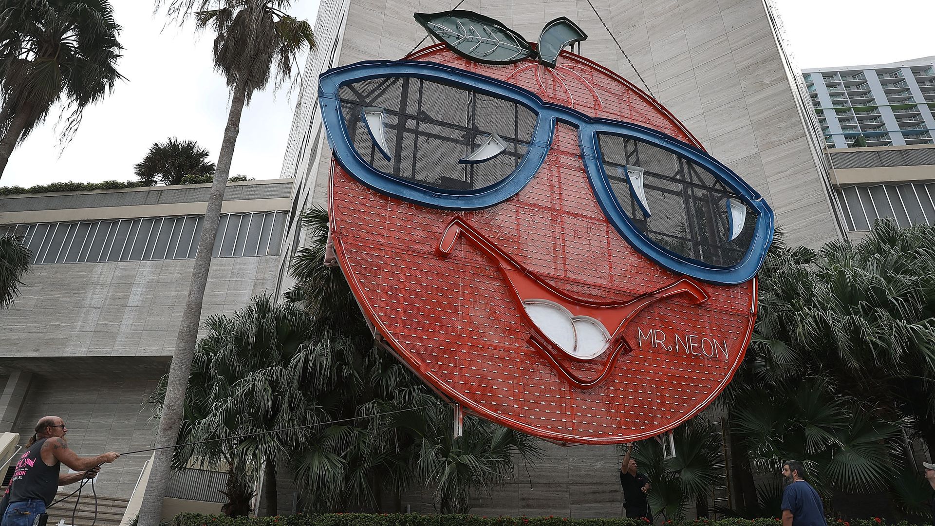 The Big Orange sculpture is hoisted onto the InterContinental Miami hotel.