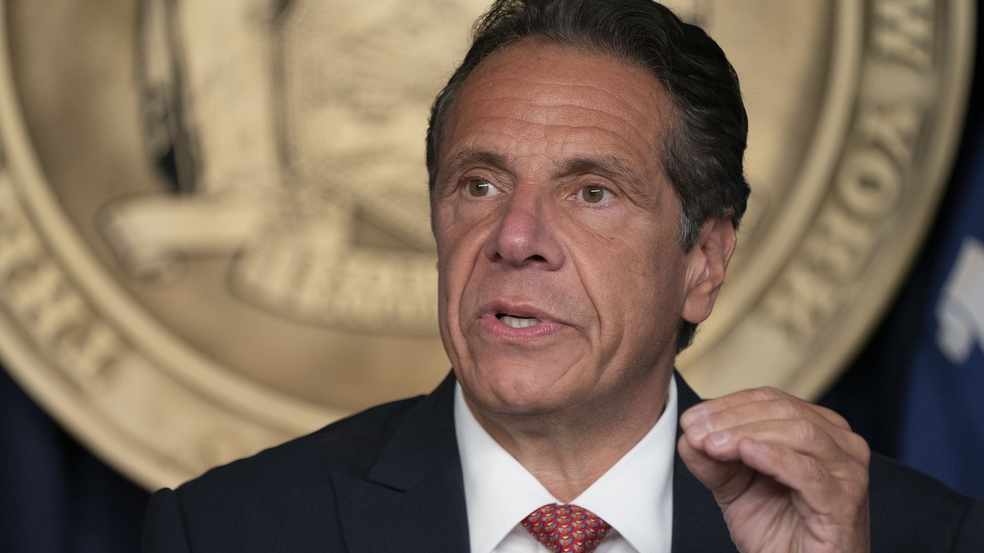 Photo of Andrew Cuomo speaking with one hand raised