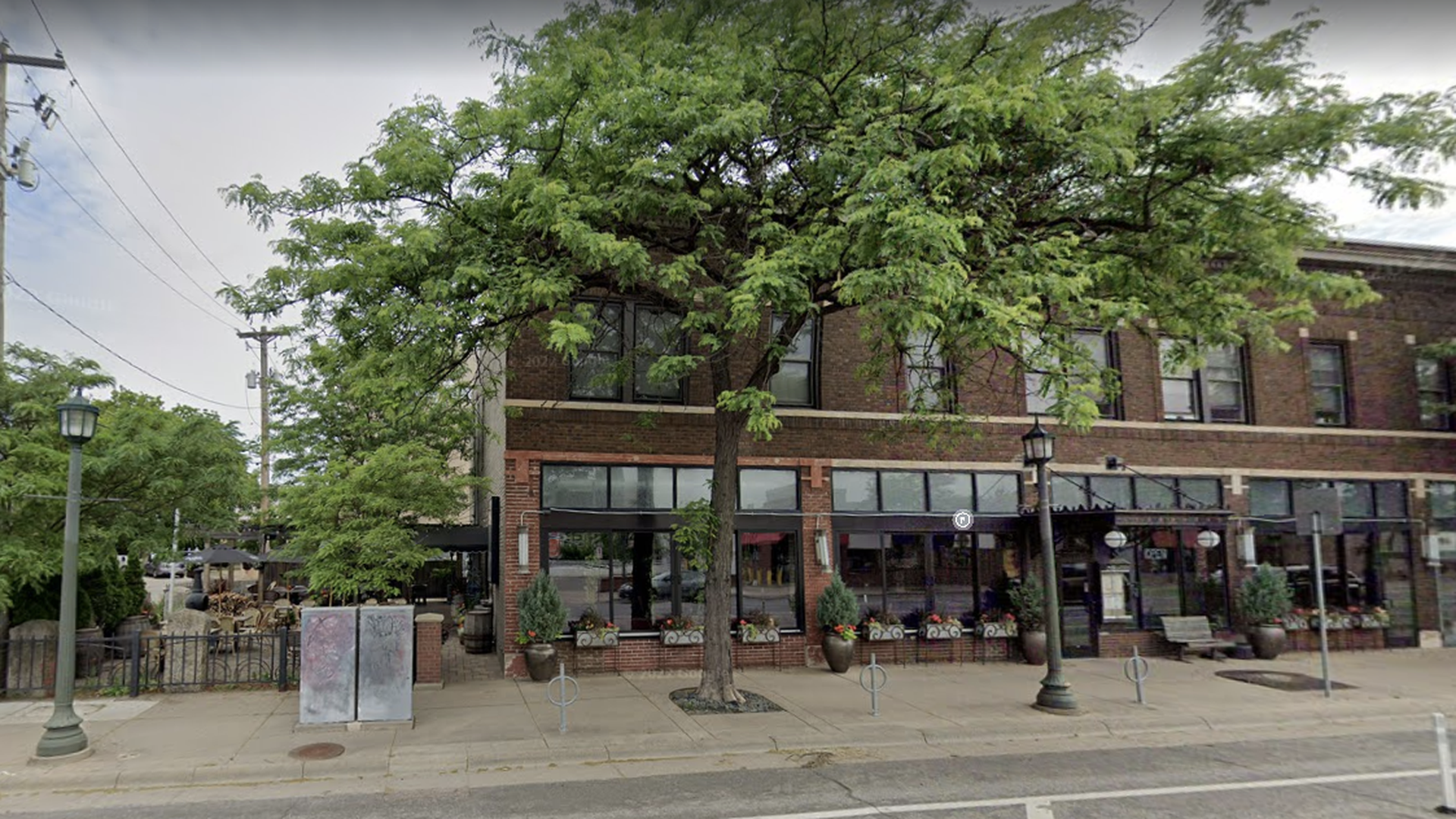 The exterior of Eat Street Social, a brown brick building with a patio on the left.
