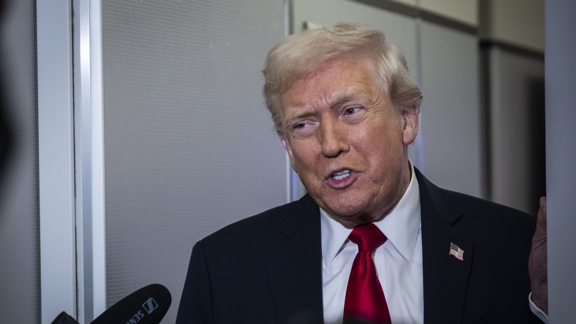 Trump wearing a blue suit jacket, white shirt and red tie