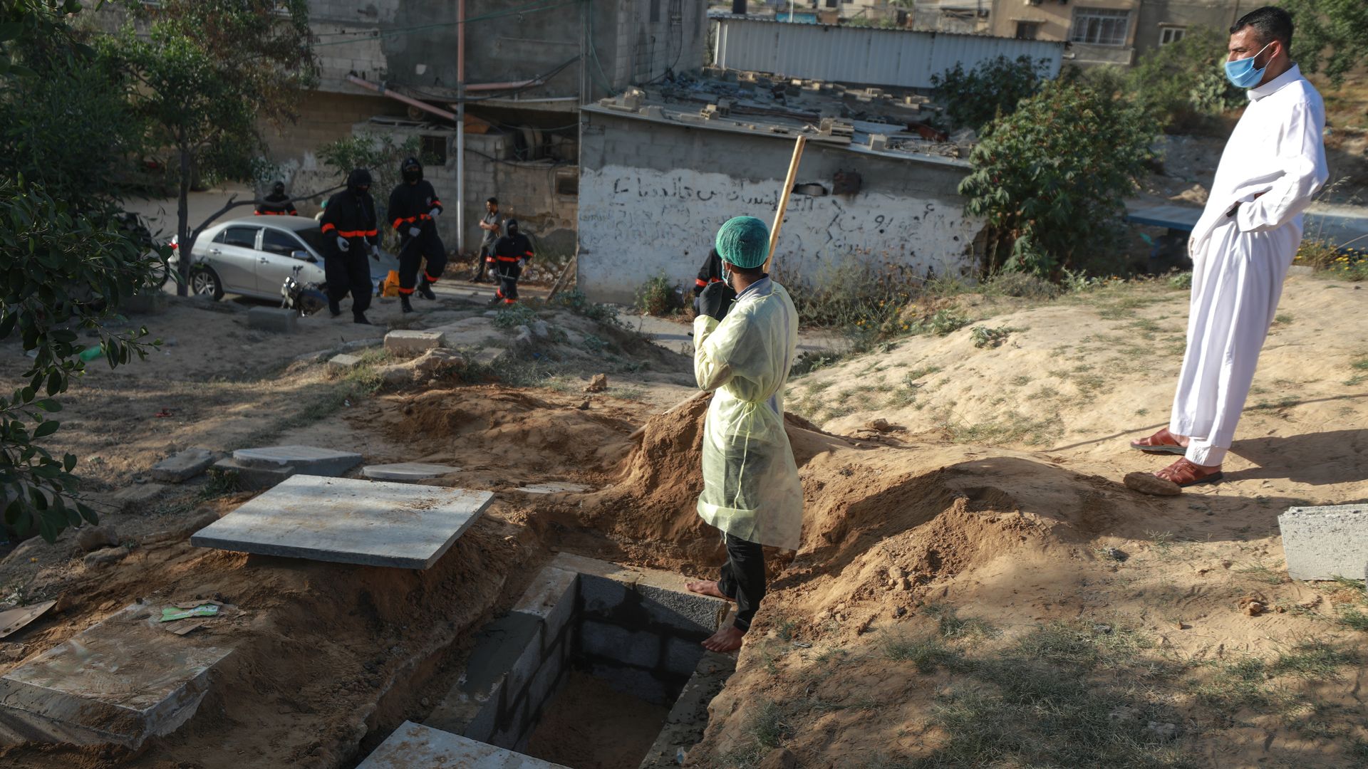 In this image, two men dig a grave