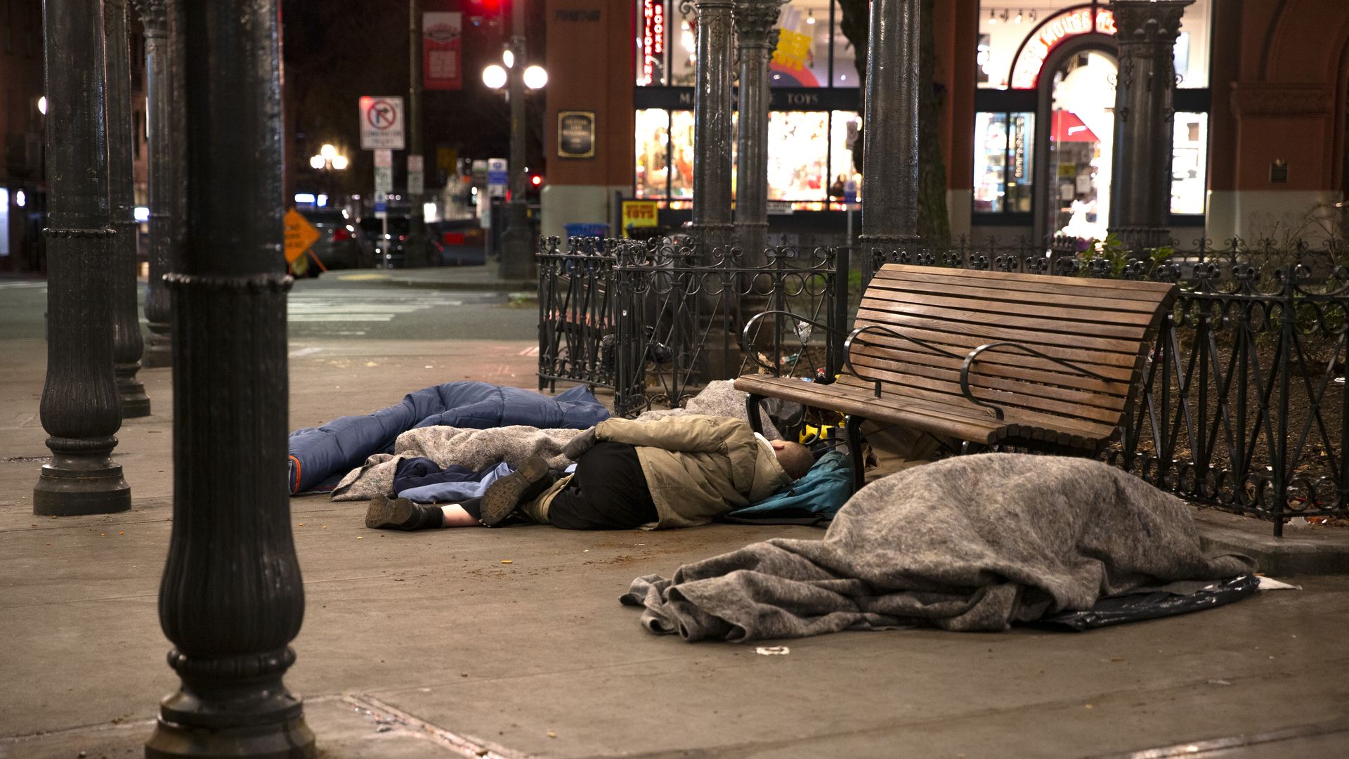 People sleeping outside on pavement in Seattle's Pioneer Square.