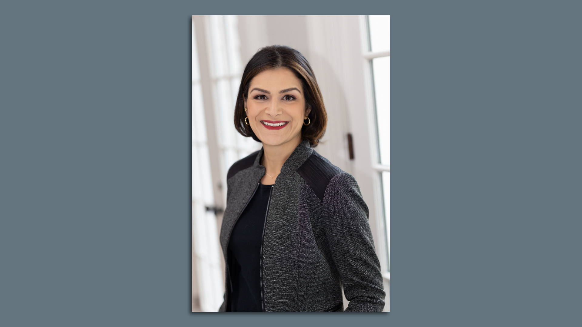 A person on a gray suit jacket and black shirt