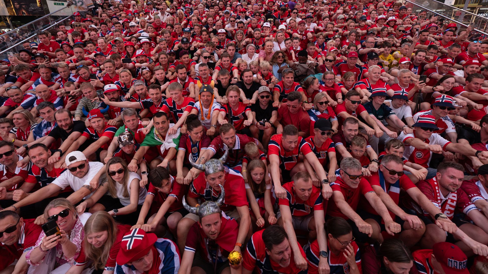 NEW YORK, UNITED STATES - JUNE 21: Norwegian national football team supporters gather on the iconic red steps in Times Square ahead of Monday's FIFA World Cup match, creating a festive atmosphere with chants and traditional rowing celebrations as fans dressed in red and waving flags filled the famou