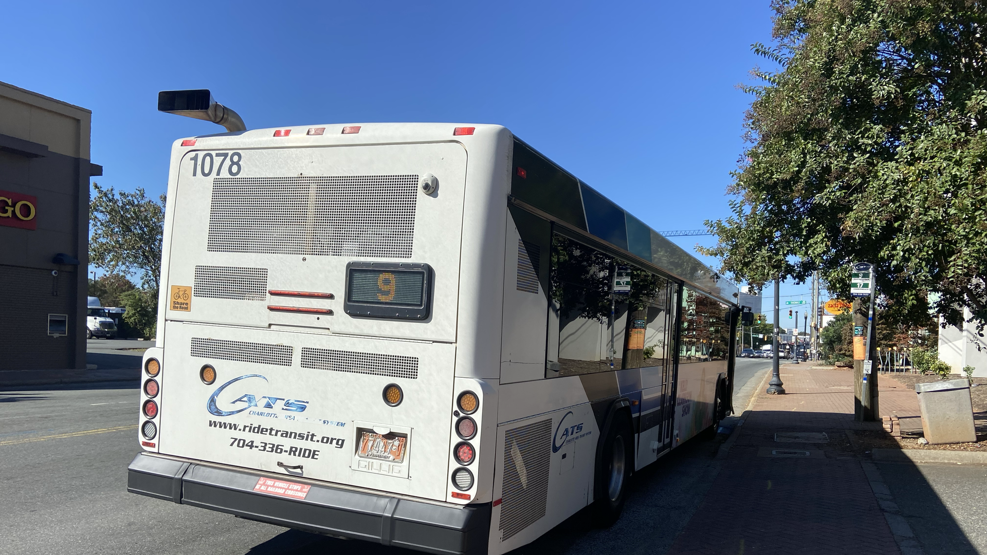 A bus labeled number 9 at a bus stop.