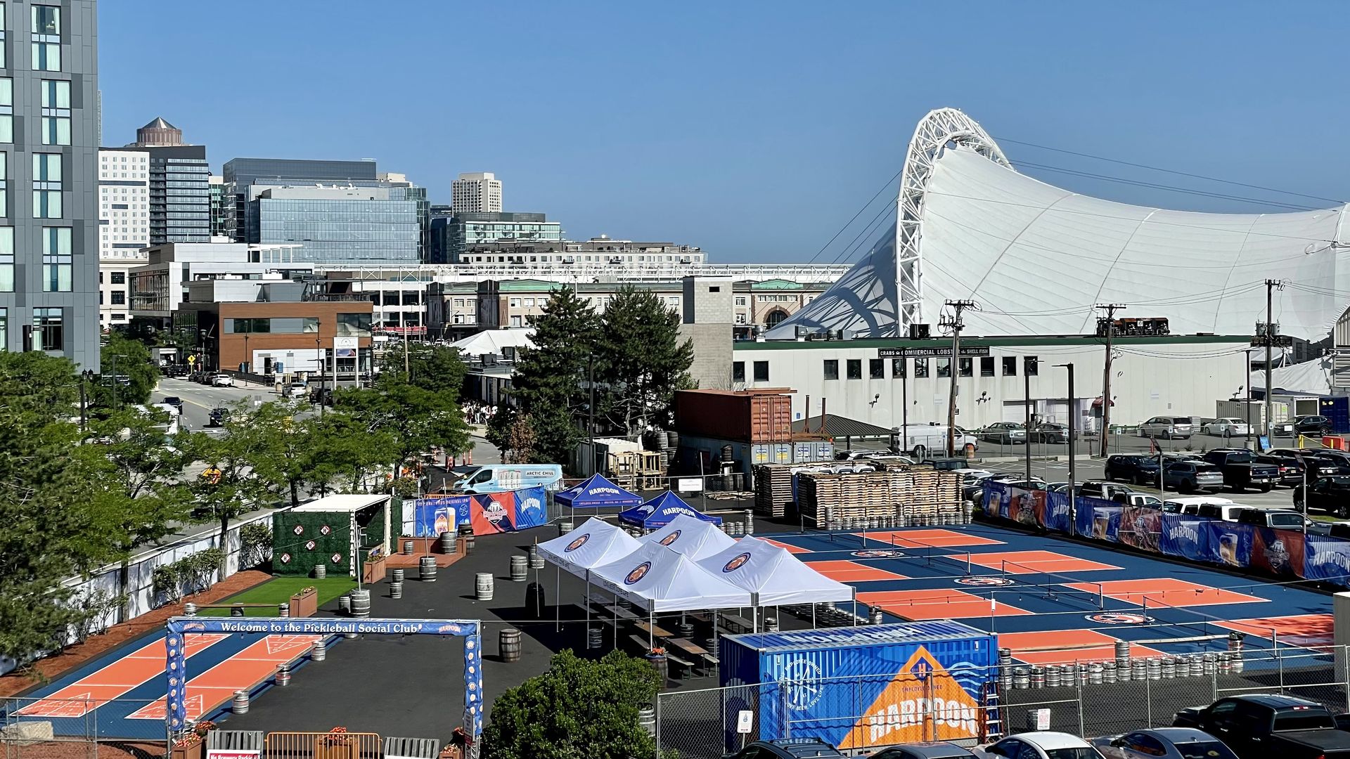A wide view showing four pickleball courts and shuffleboard courts next to Harpoon Brewery in Boston's Seaport.