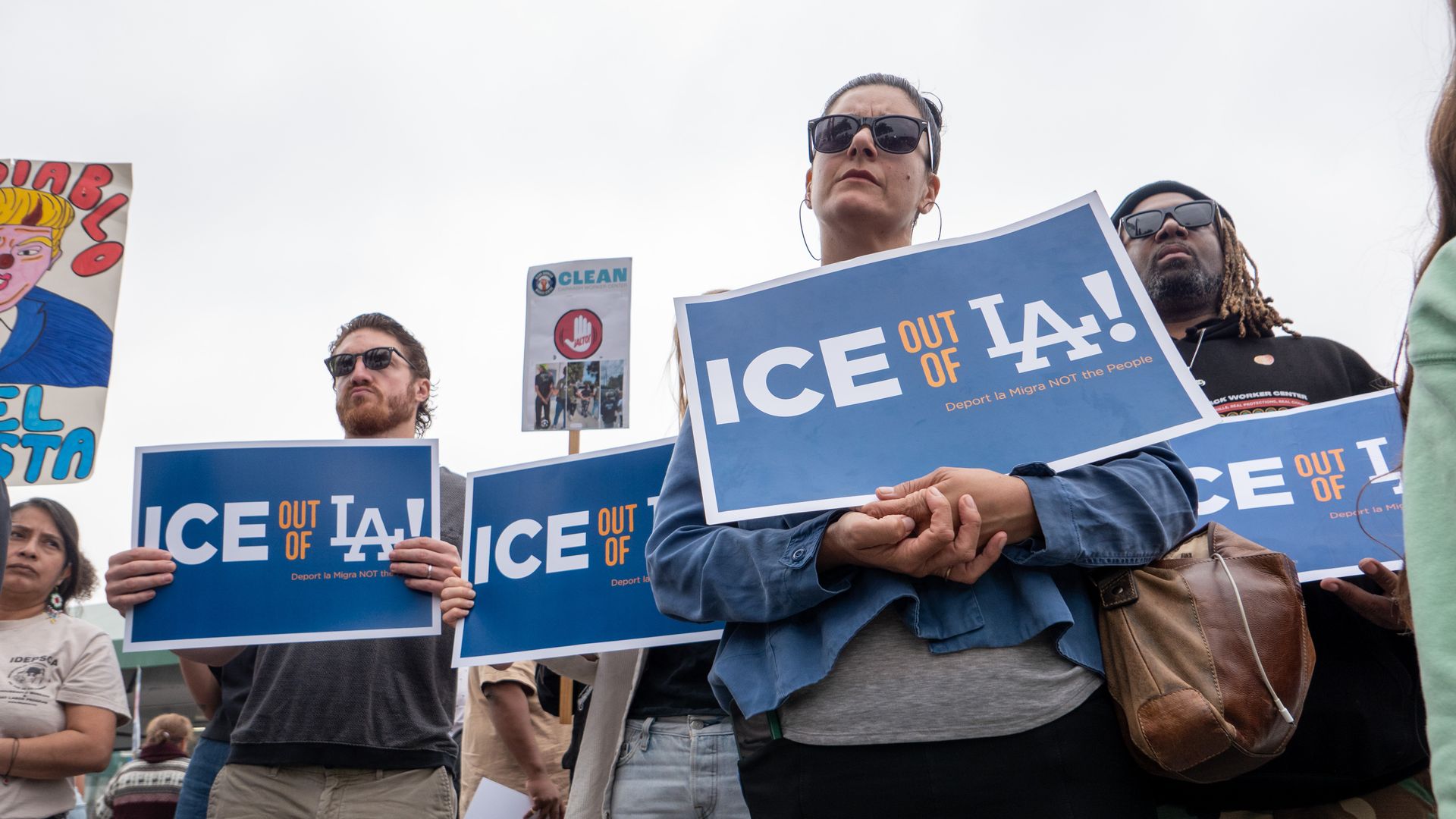 Protesters carry signs saying ICE out of LA.