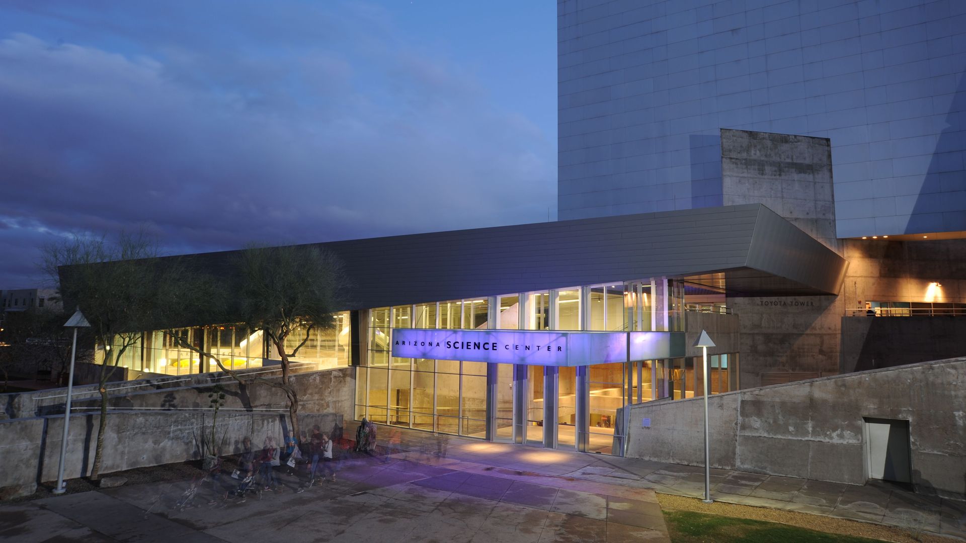 A building at night with an illuminated purple sign that says Arizona Science Center. 