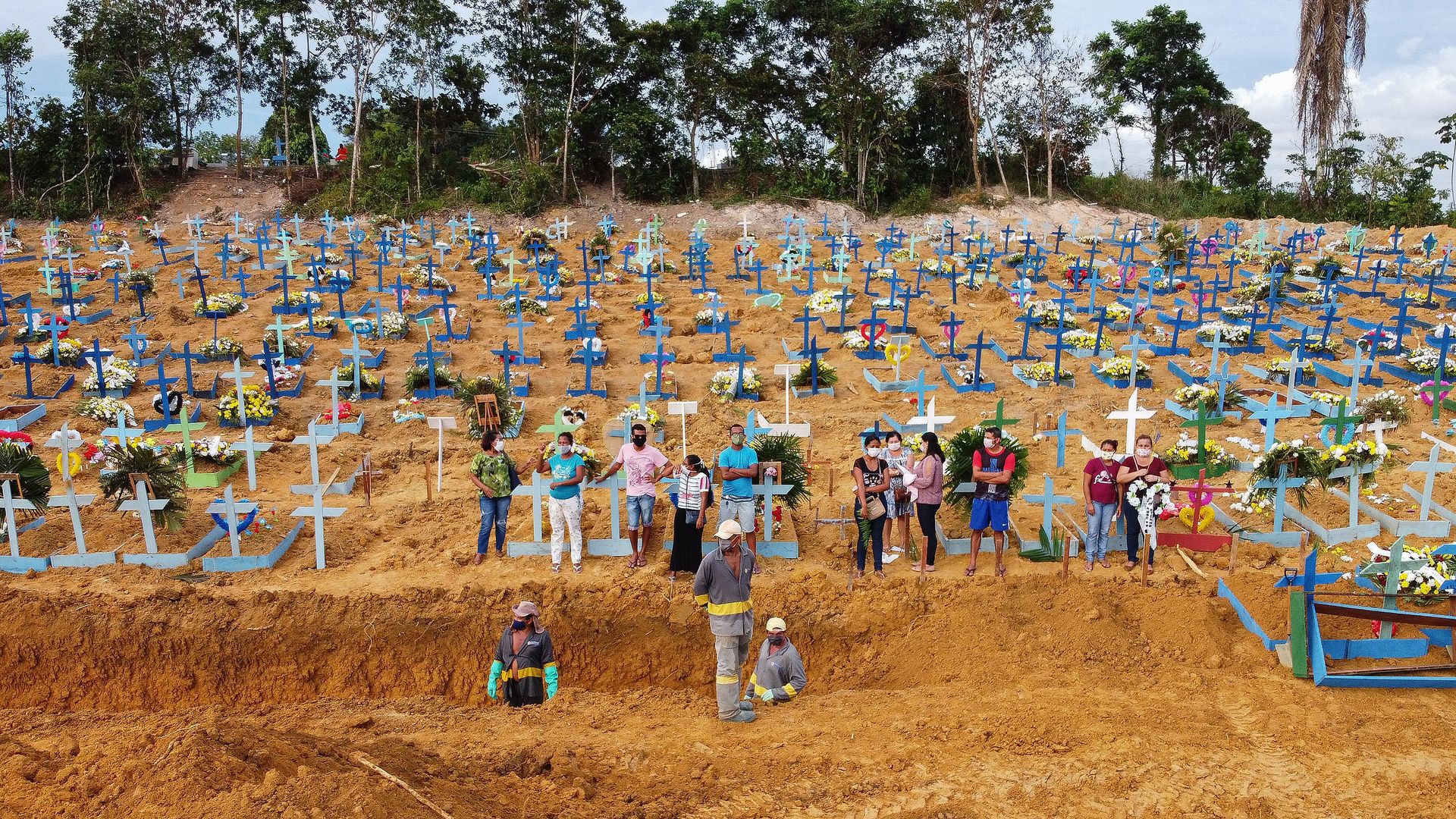 Rows and rows of crosses in a dirt field 