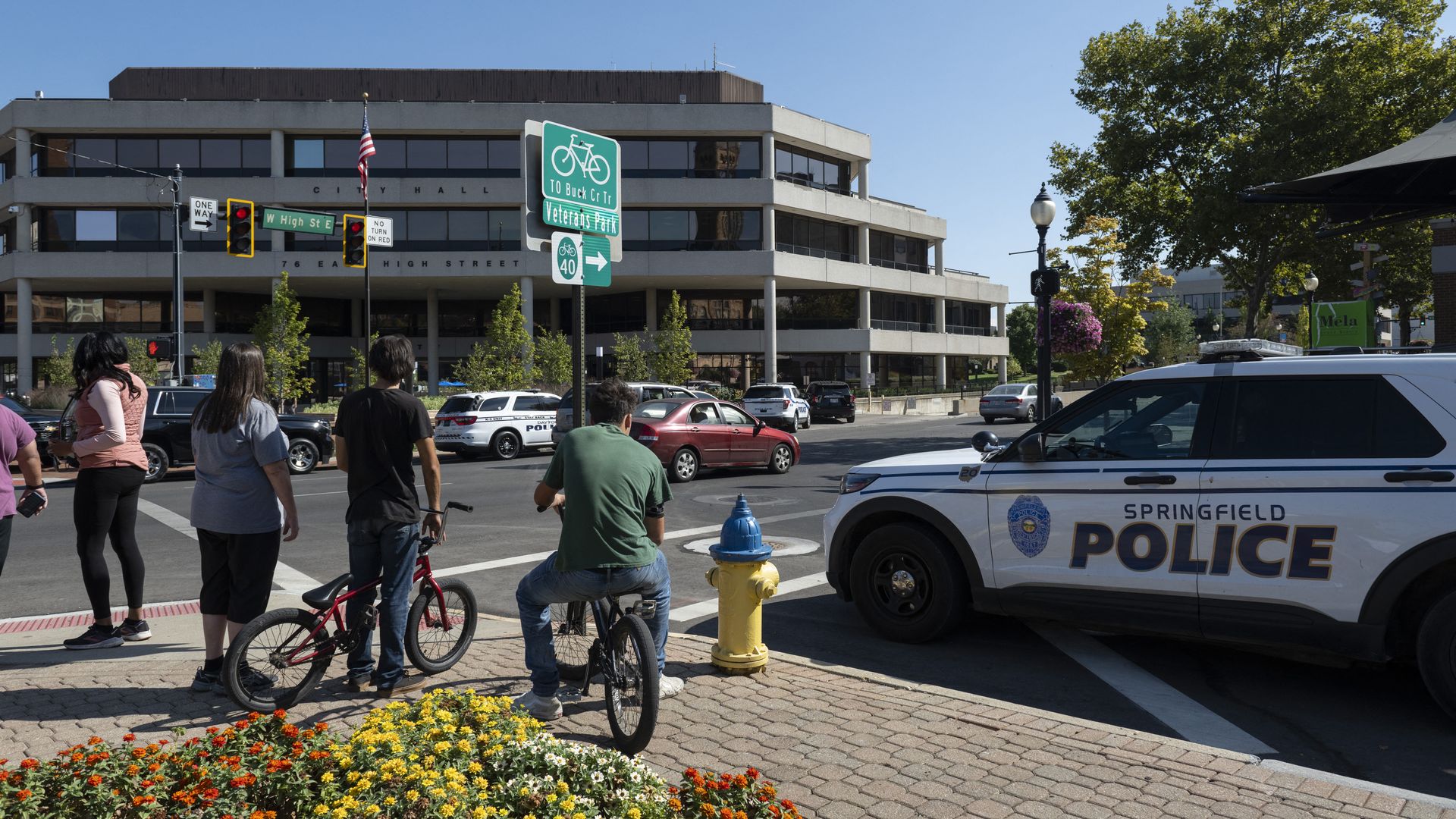 People watch as Springfield Police Department officers investigate the Springfield City Hall after bomb threats were made against buildings earlier in the day in Springfield, Ohio on September 12, 2024. 