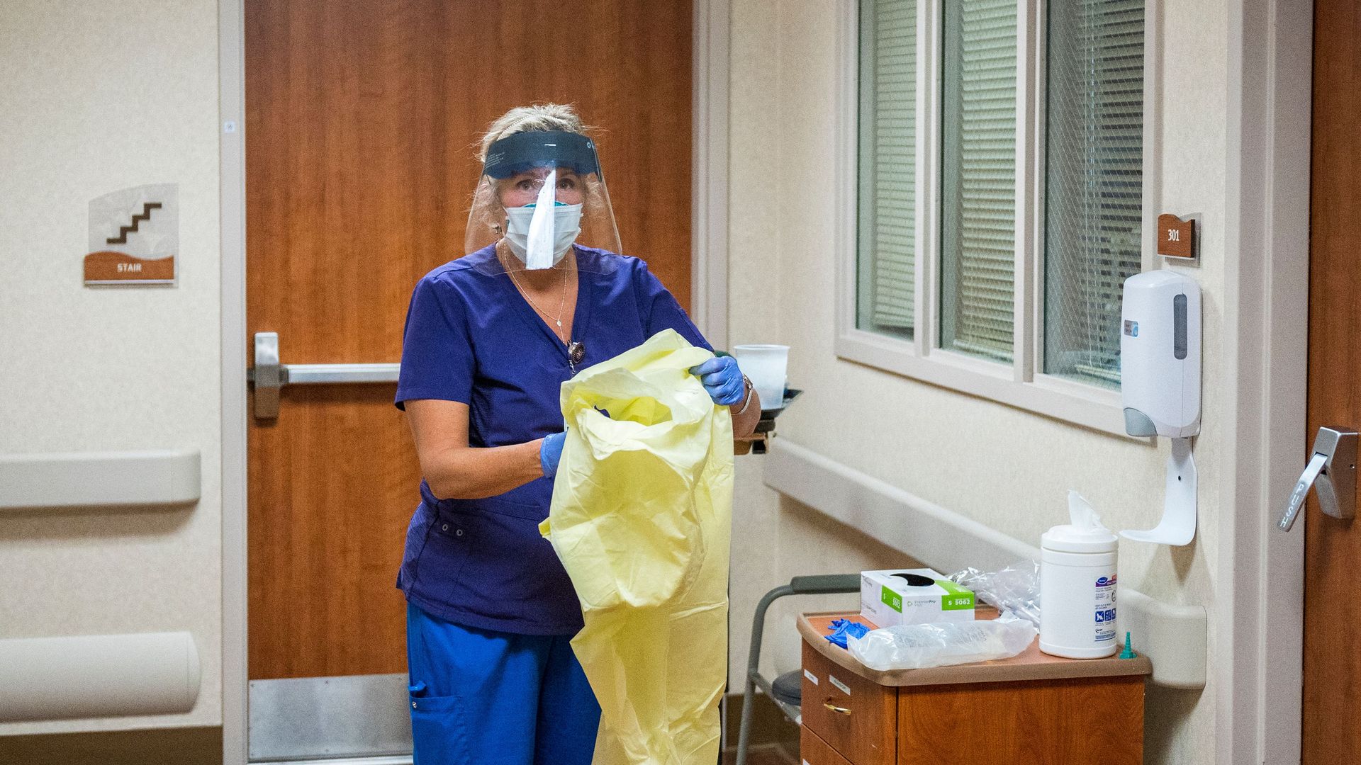 A nurse puts on protective equipment in a hospital