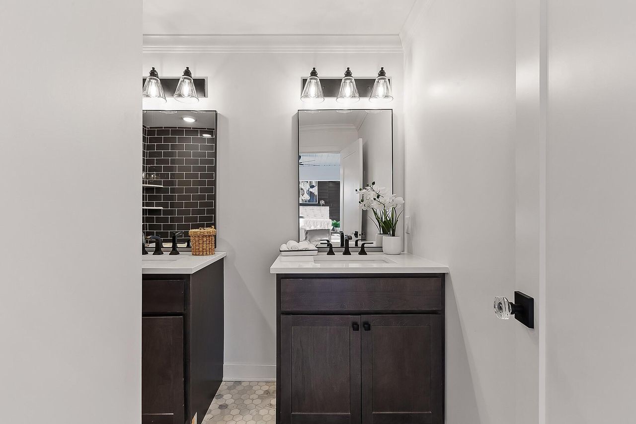 refreshed bathroom with dark tile and storage space