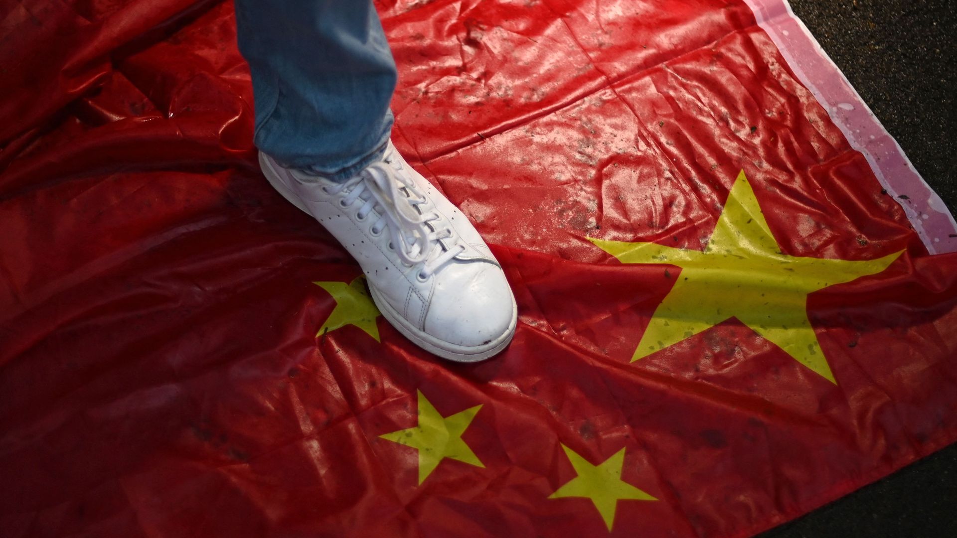 Photo of a foot planted on a Chinese flag 