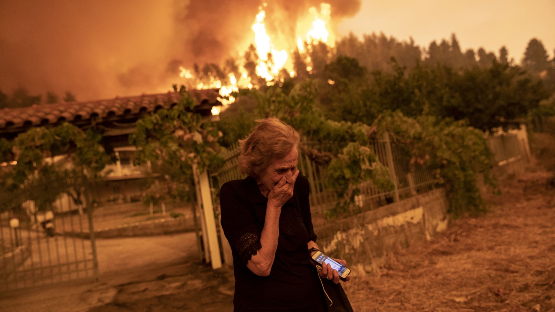 A person reacting to a wildfire approaching her house on the island of Evia, Greece, on Aug. 8.