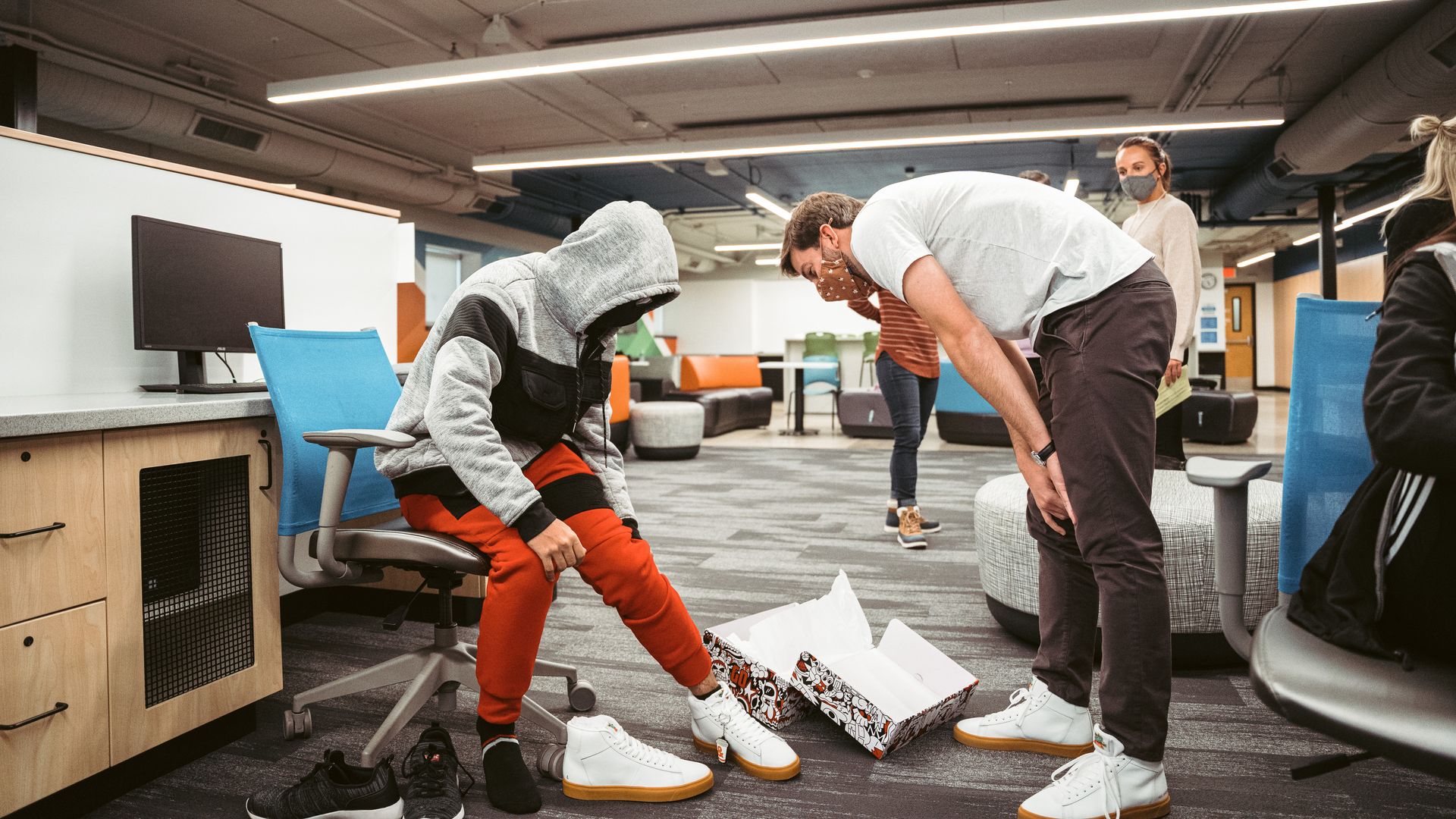 Tanner Krause talks with a kid trying on Kum & Go shoes