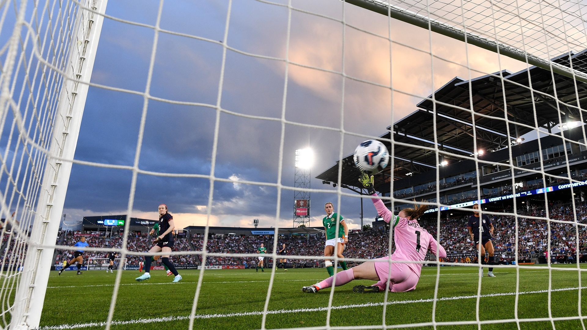The inside of a soccer net, showing one player diving while another stands by after scoring. 