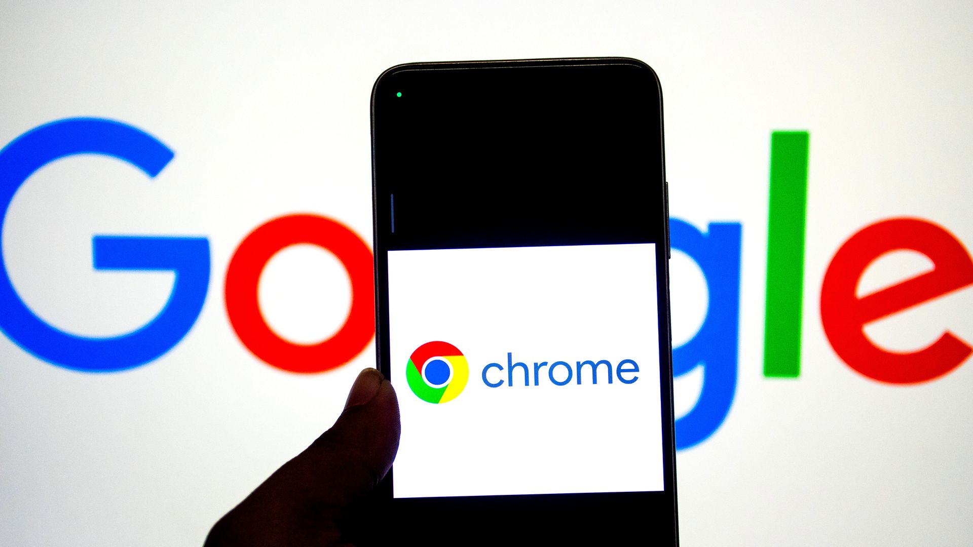 n this photo illustration, a Google Chrome logo seen displayed on a smartphone with a Google Logo in the background. 