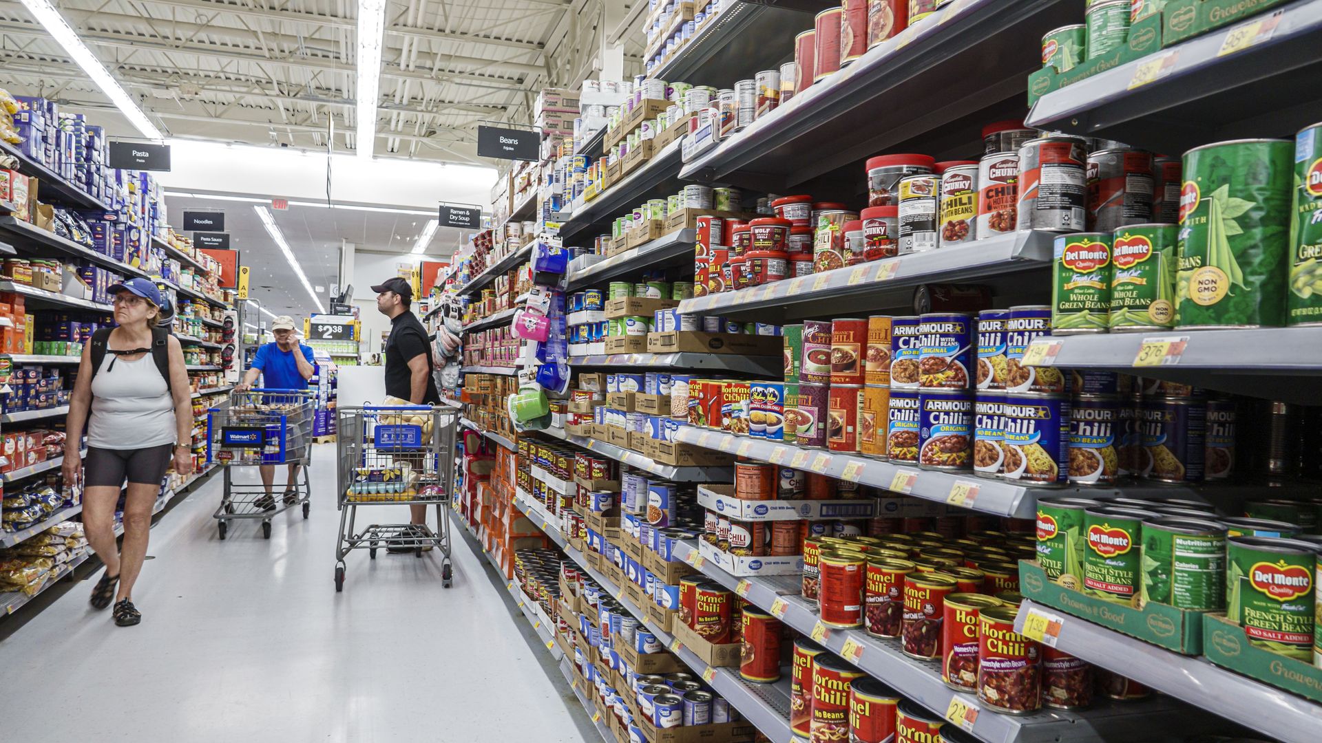 Shoppers at a Walmart in Florida standing in the canned goods aisle. 