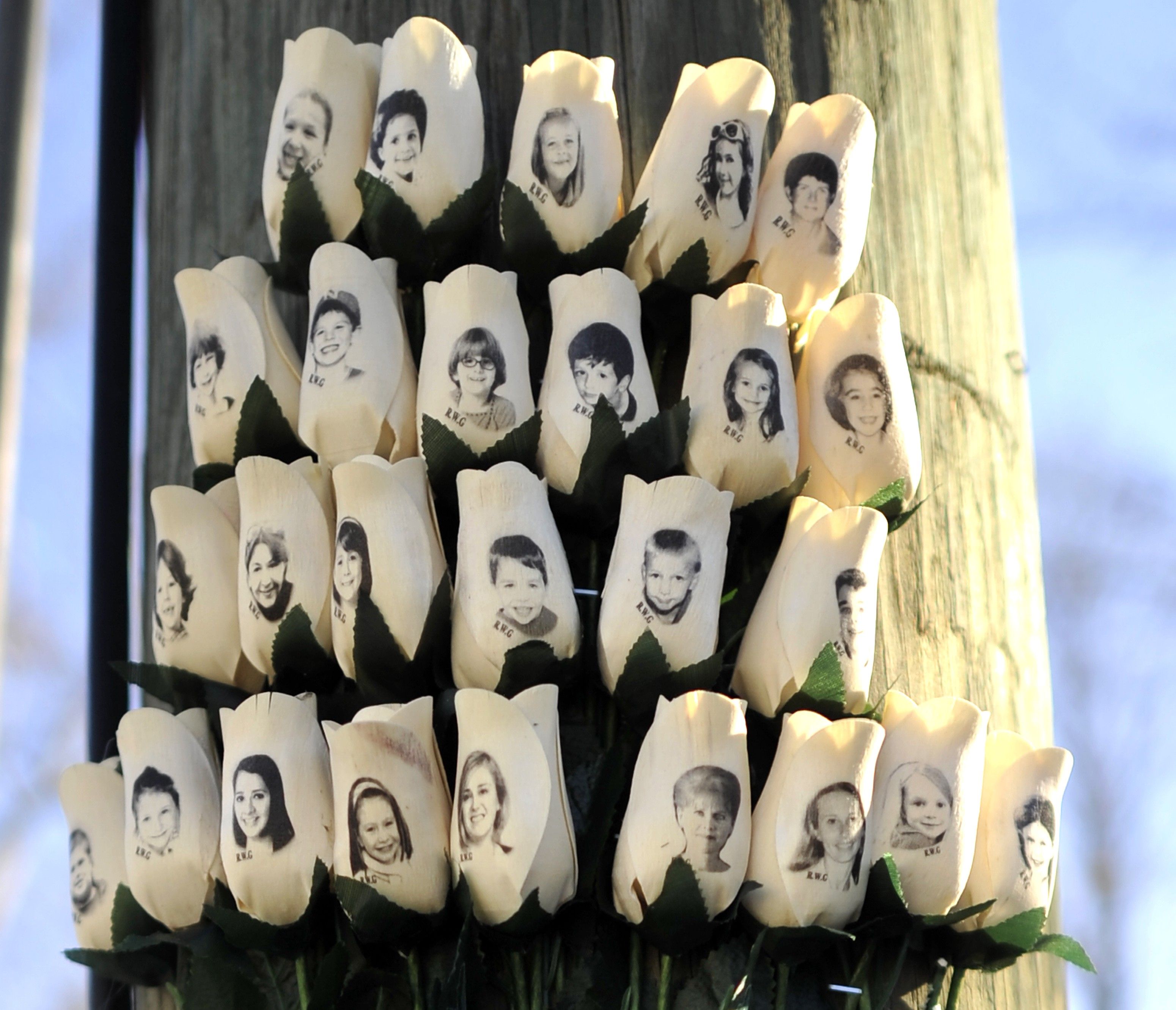 Roses with the faces of the Sandy Hook Elementry students and adults killed are seen on a pole in Newtown, Connecticut on January 3, 2013. 