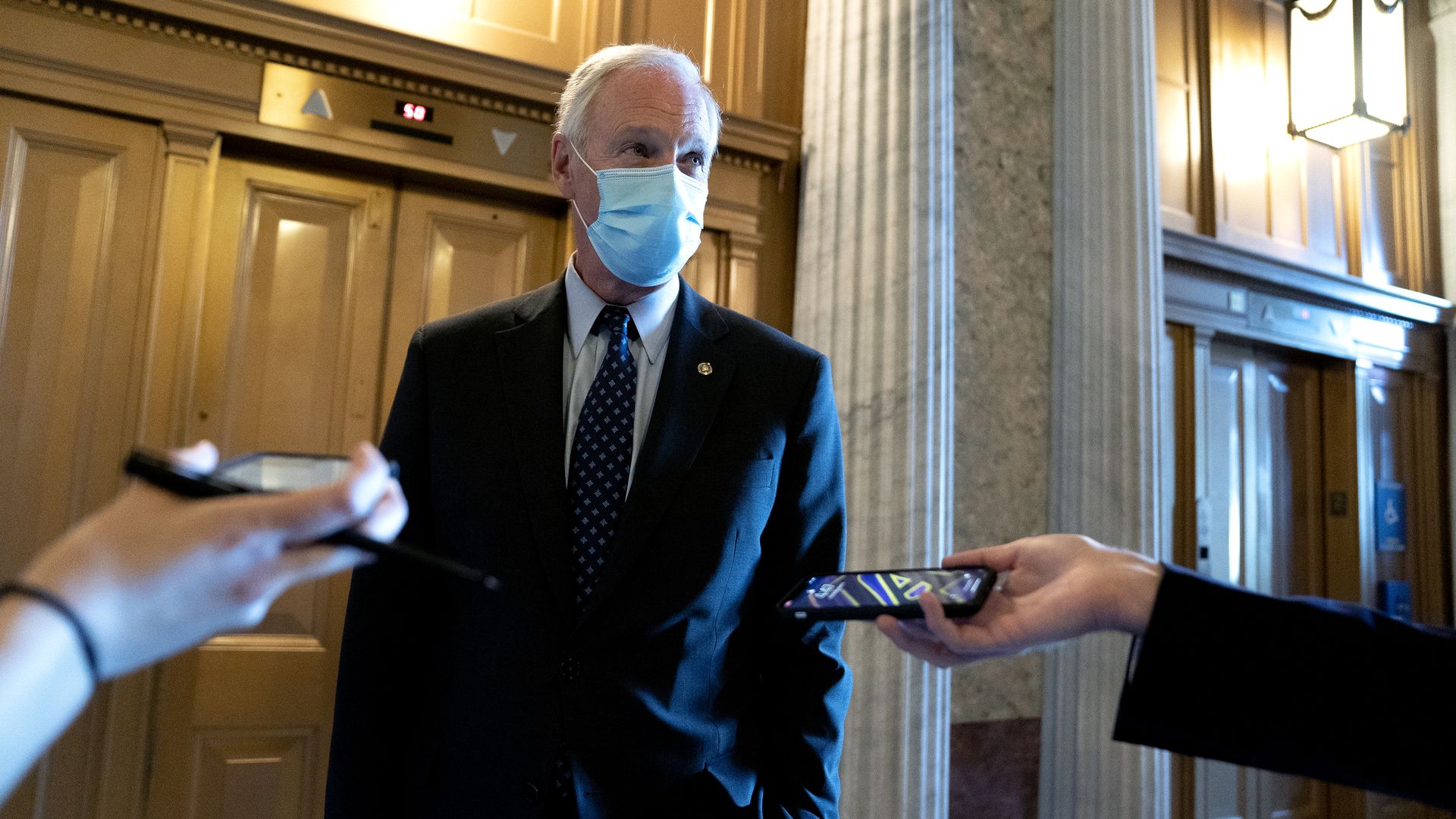 Sen. Ron Johnson is seen speaking with a pair of reporters.