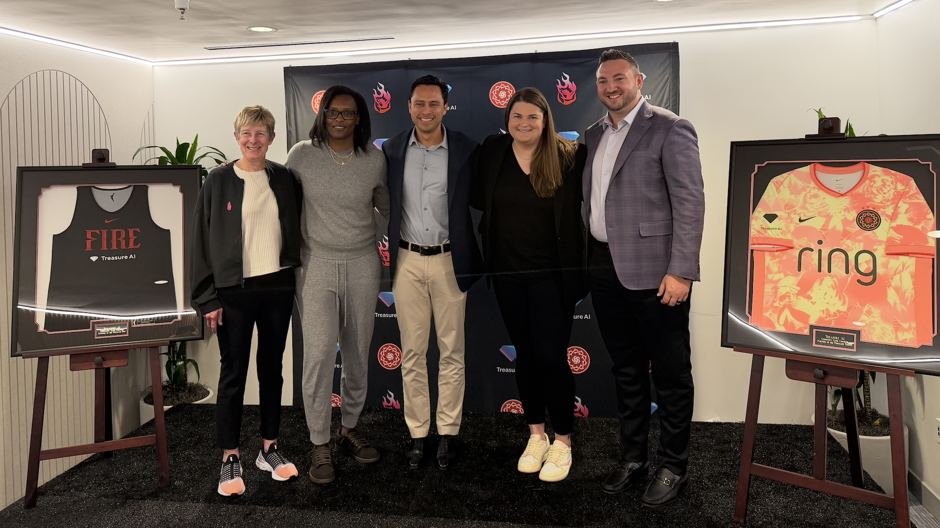 Executives from the Portland Fire and Treasure AI unveil jerseys featuring the AI company's logo.