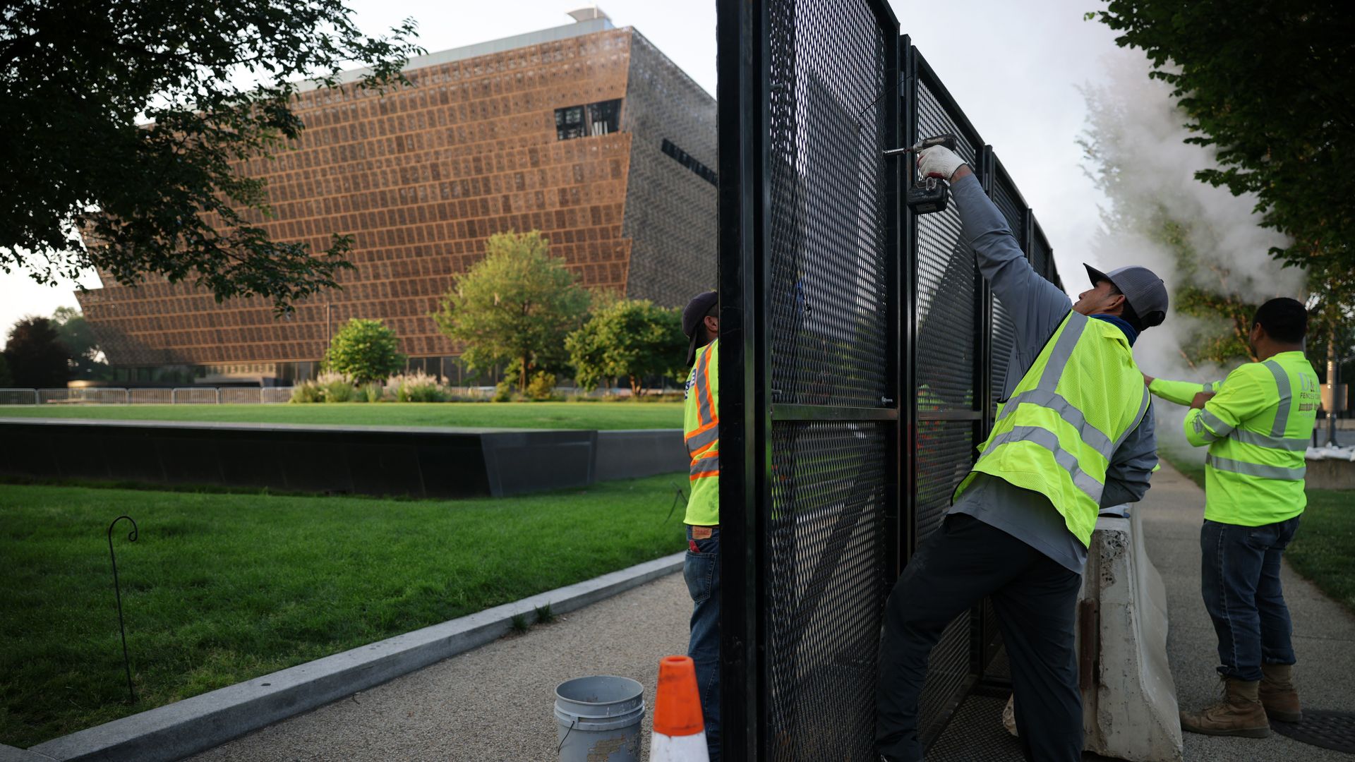 A photo of workers installing a security fence in front of the National Museum of African-American History and Culture on the National Mall.