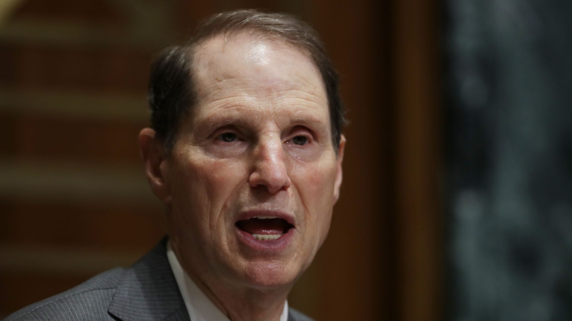Sen. Ron Wyden speaks, wearing a suit