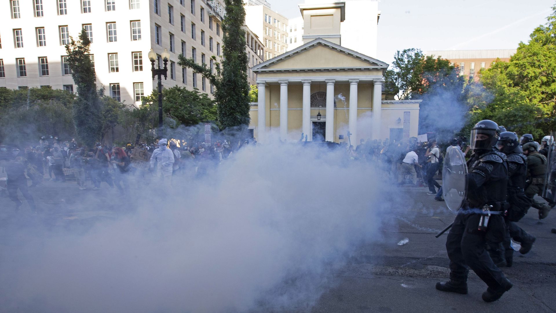 Police and security officers use tear gas to disperse protestors in front of St. Johns