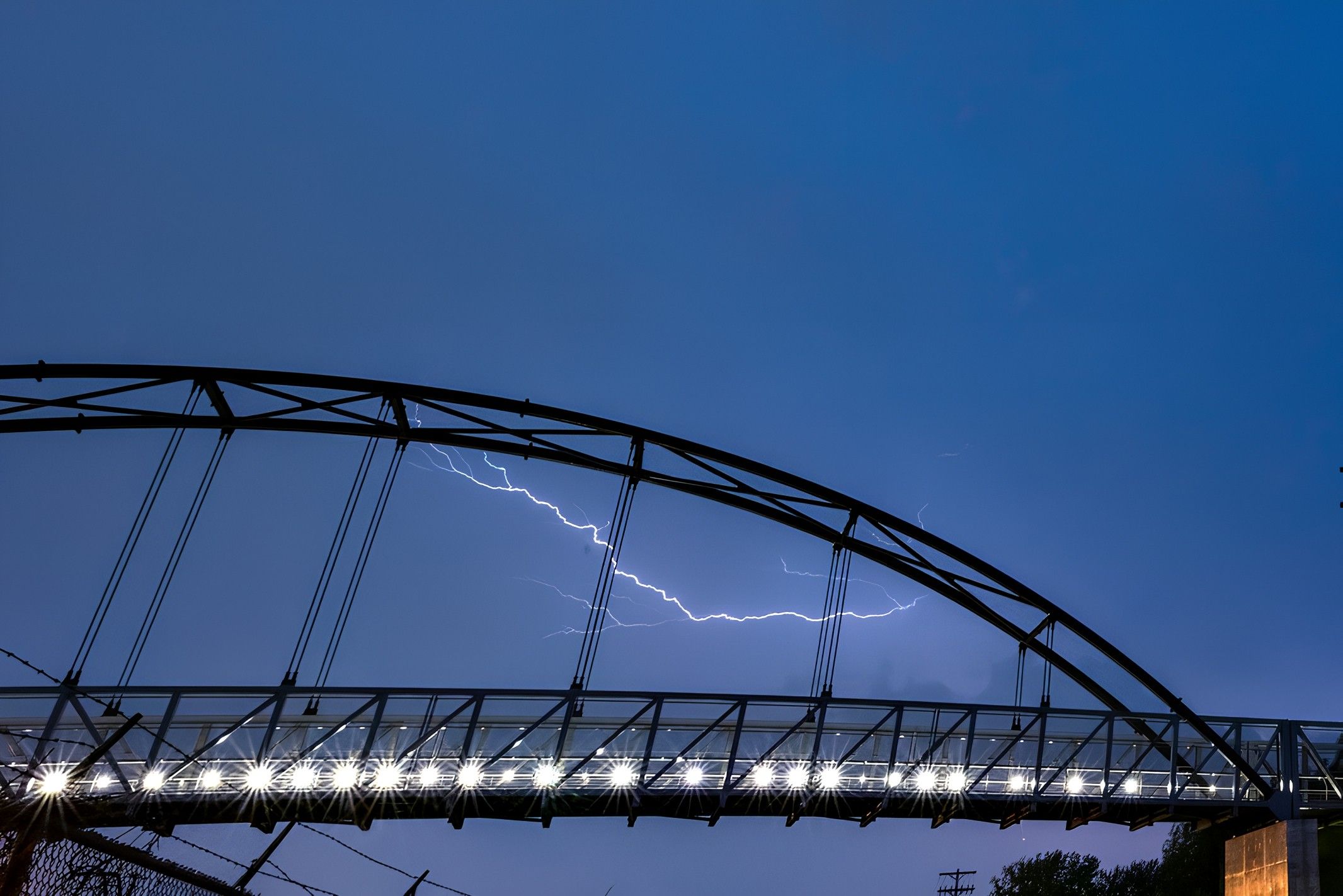 Lightning in the sky beyond a bridge. 
