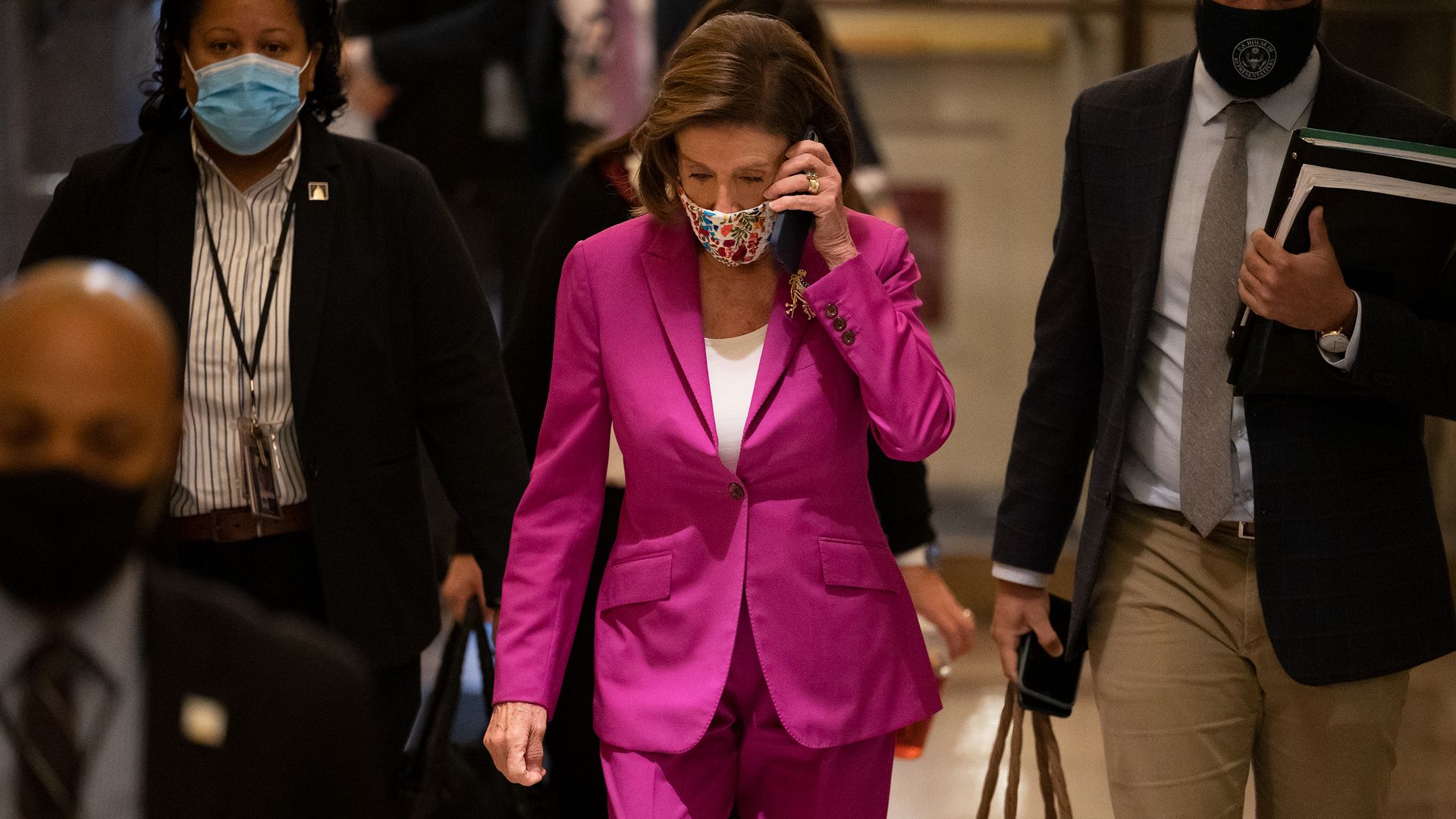 Pelosi walks holding cell phone