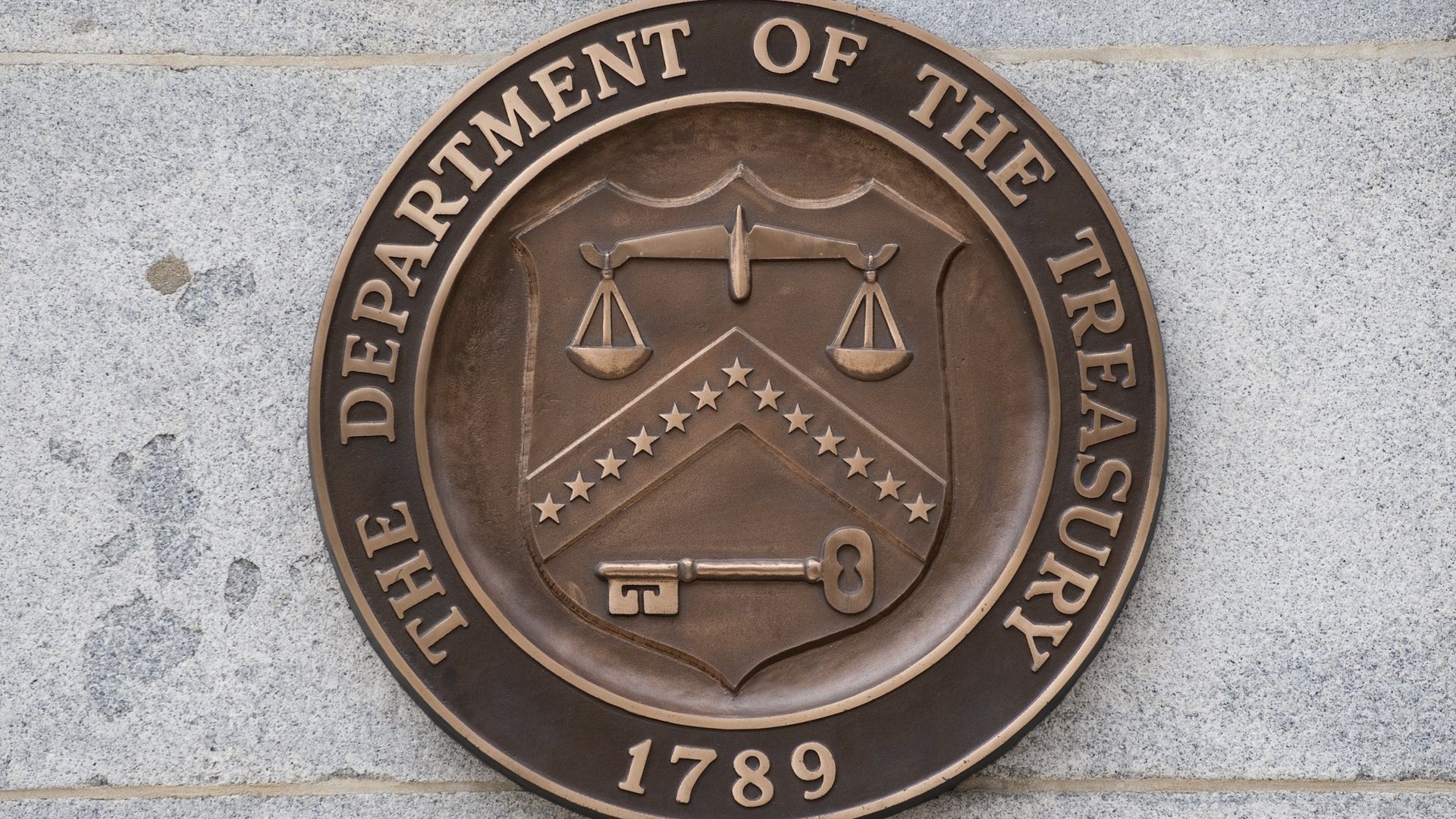 This image shows the symbol of the Treasury Department as seen hanging on a wall.
