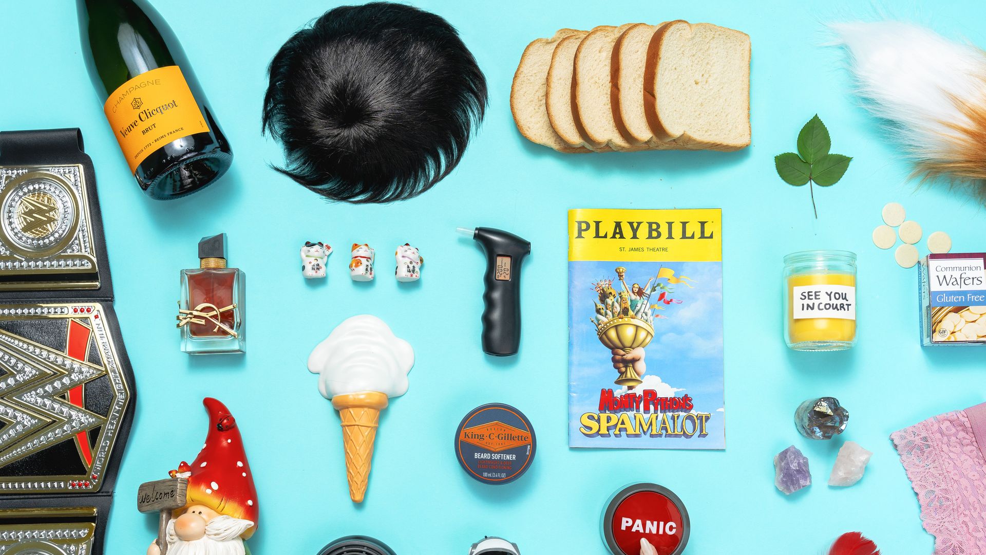 A table with weird objects on it, like bread, a toupee, a fox tail, and ice cream cone and a gnome
