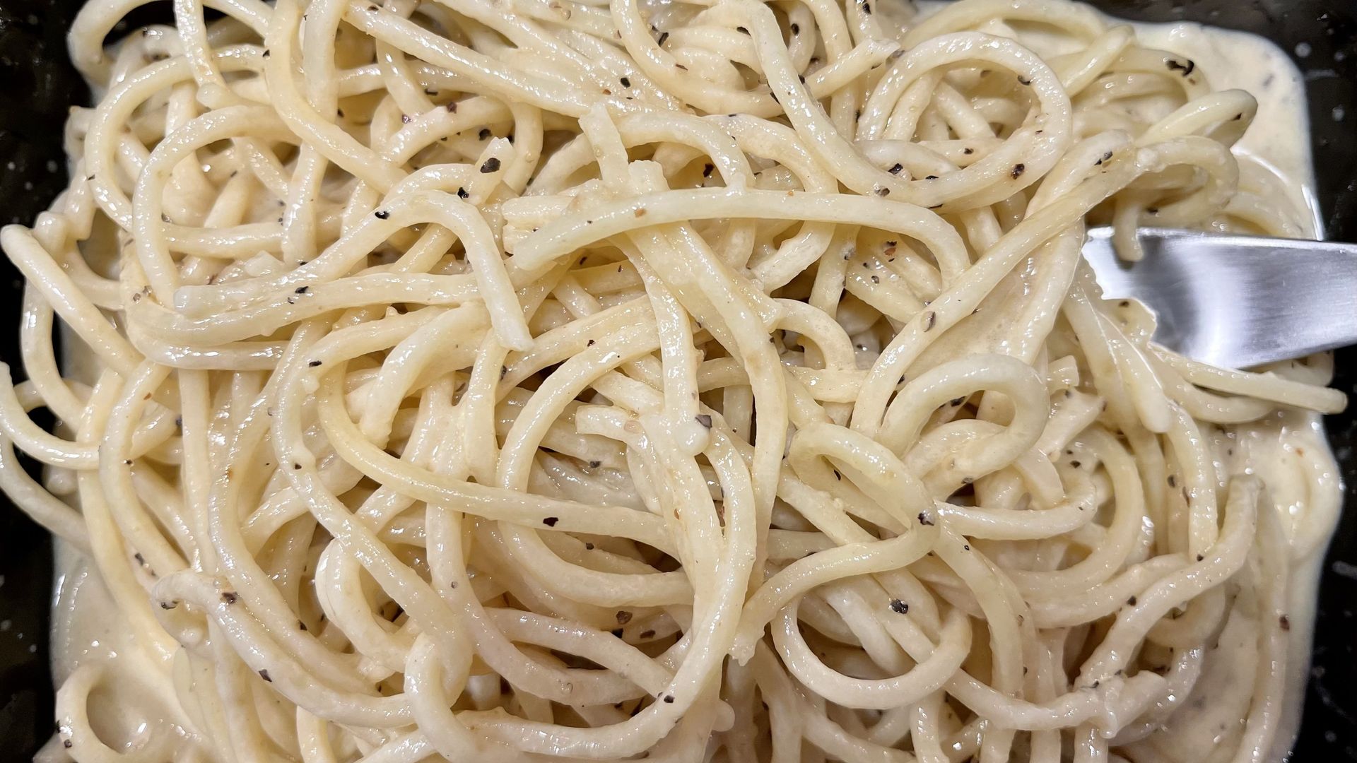 a takeout container of cacio e pepe