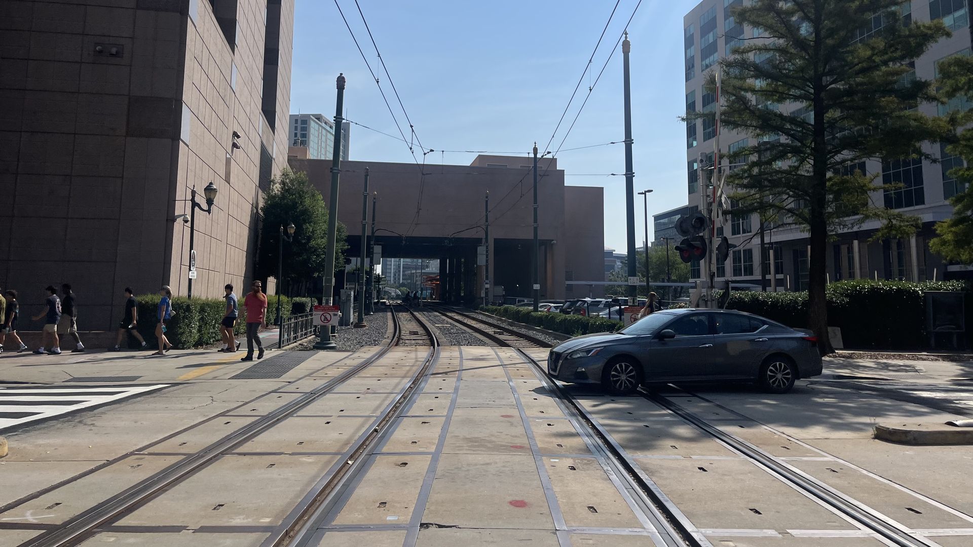 A car drives over light rail tracks